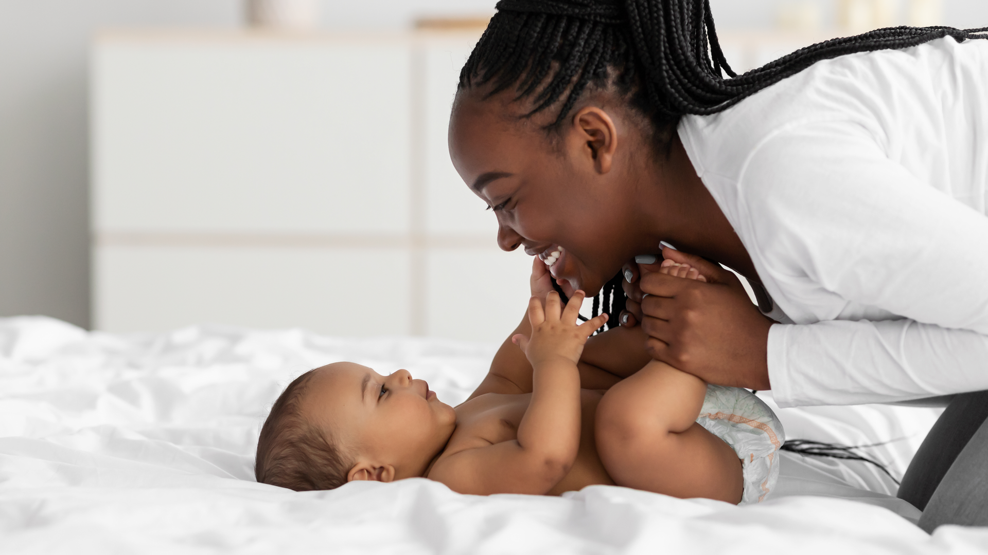 Closeup profile of black mother playing with infant