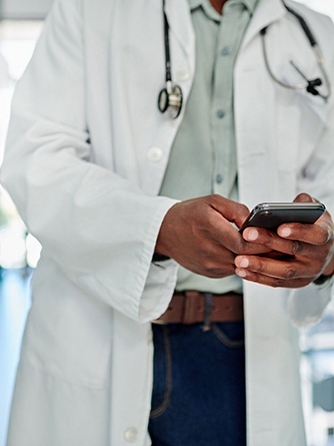 A physician is shown responding to a text on his cellphone