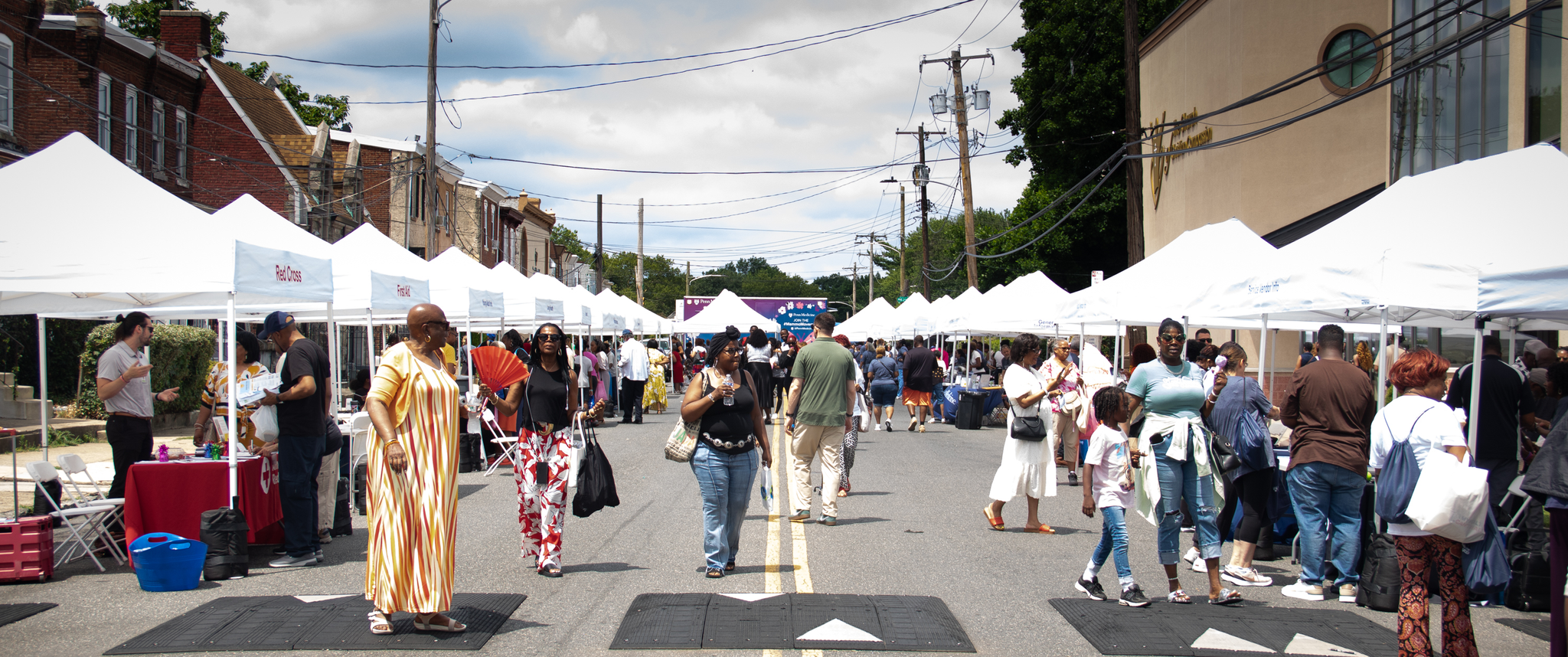 People walking among health fair tents