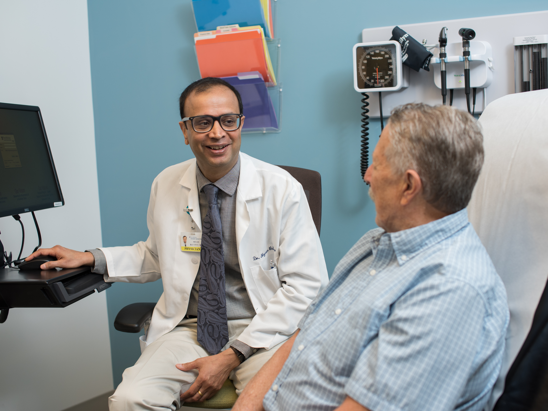 Hematology Oncologist, Shyam Balepur, MD, talks happily with patient at the Ann B. Barshinger Cancer Institute