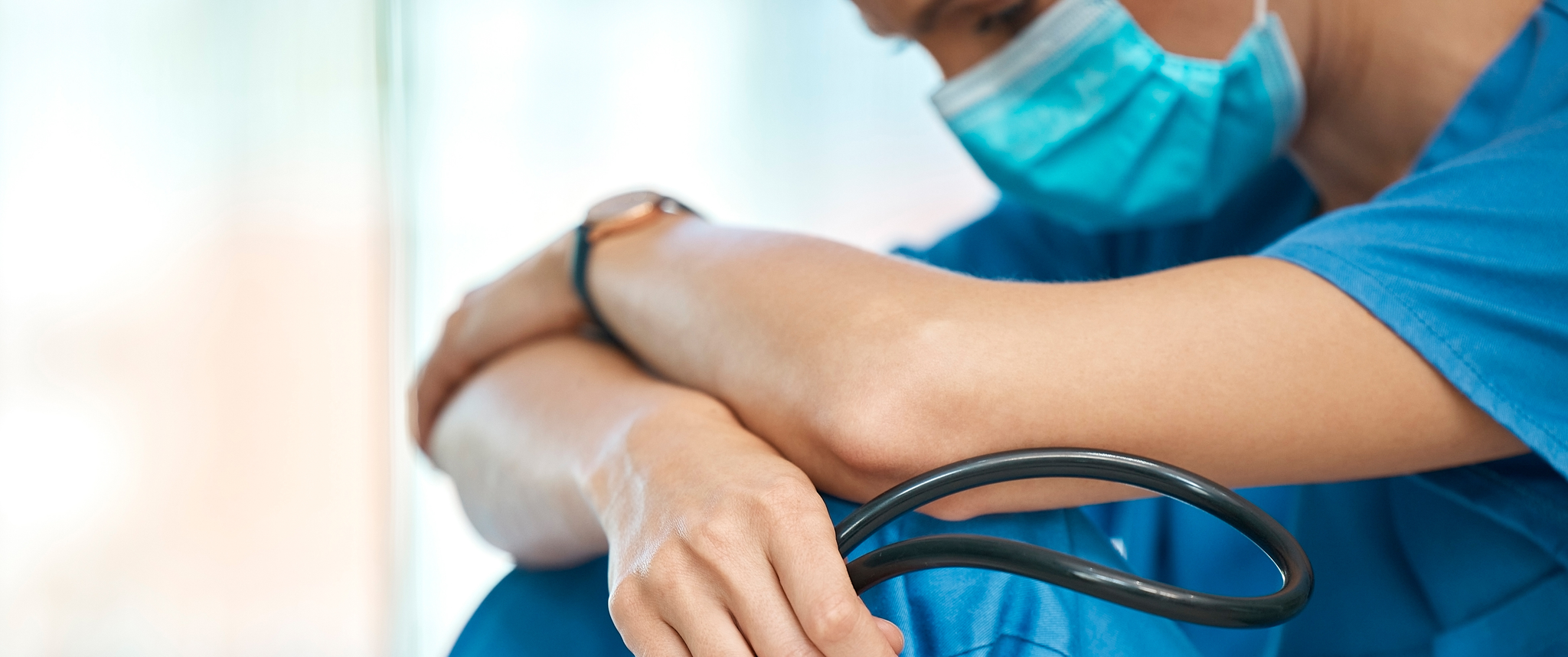 Doctor sits on ground looking tired 