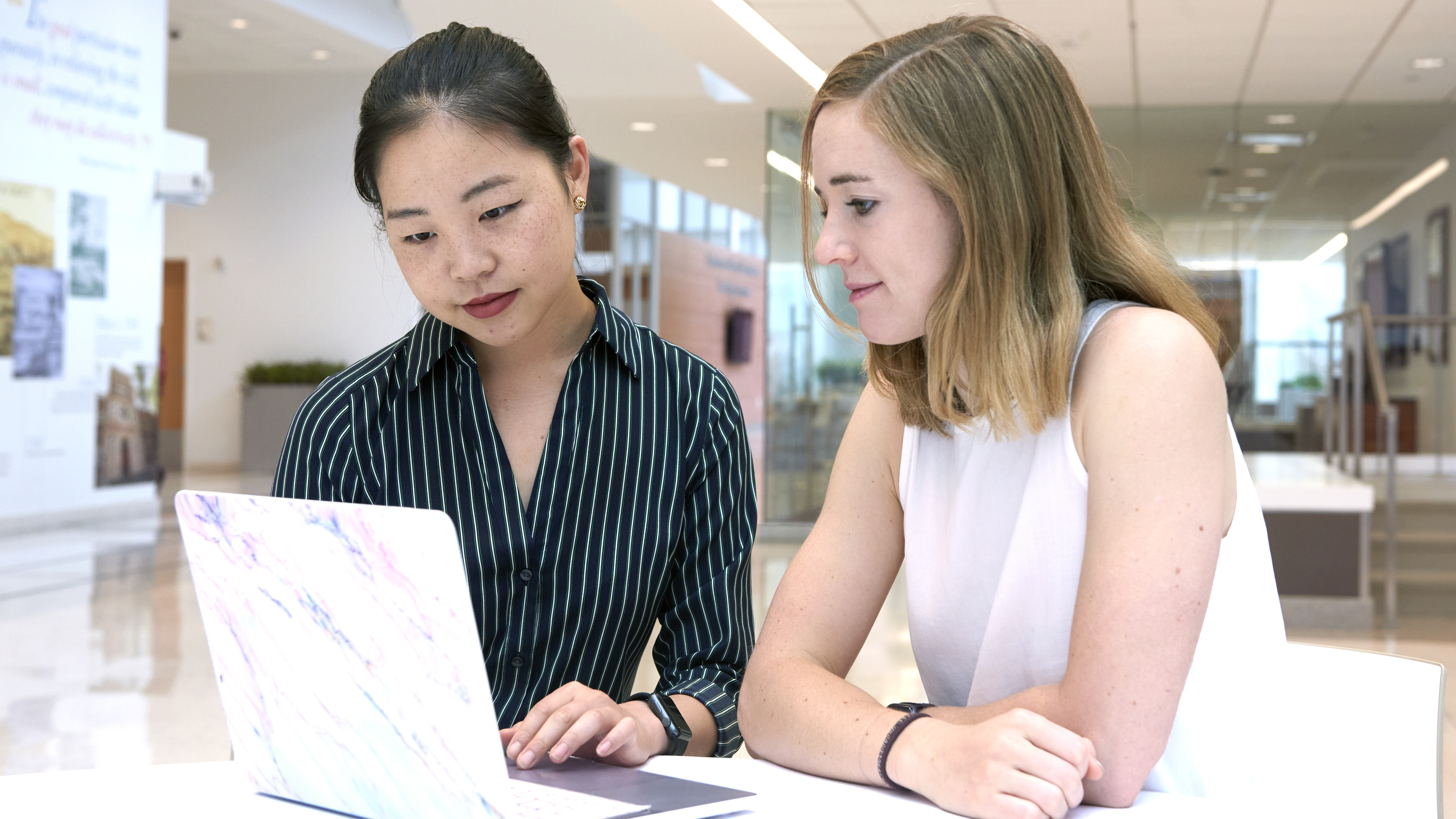 Emily Xu and Danielle Brown look at a laptop together