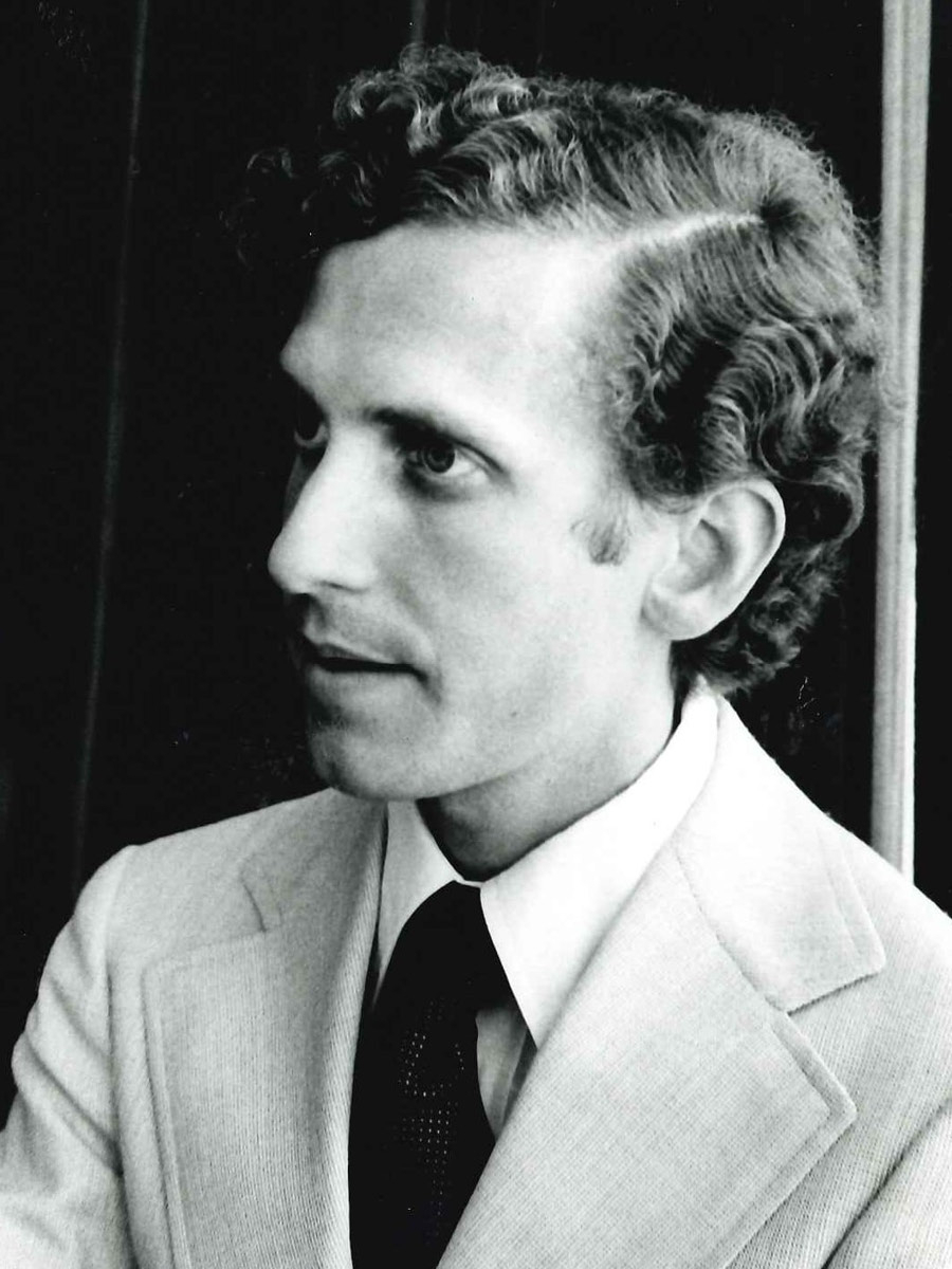 A black and white photo of John Glick as a young man in the 1970s, seen in profile
