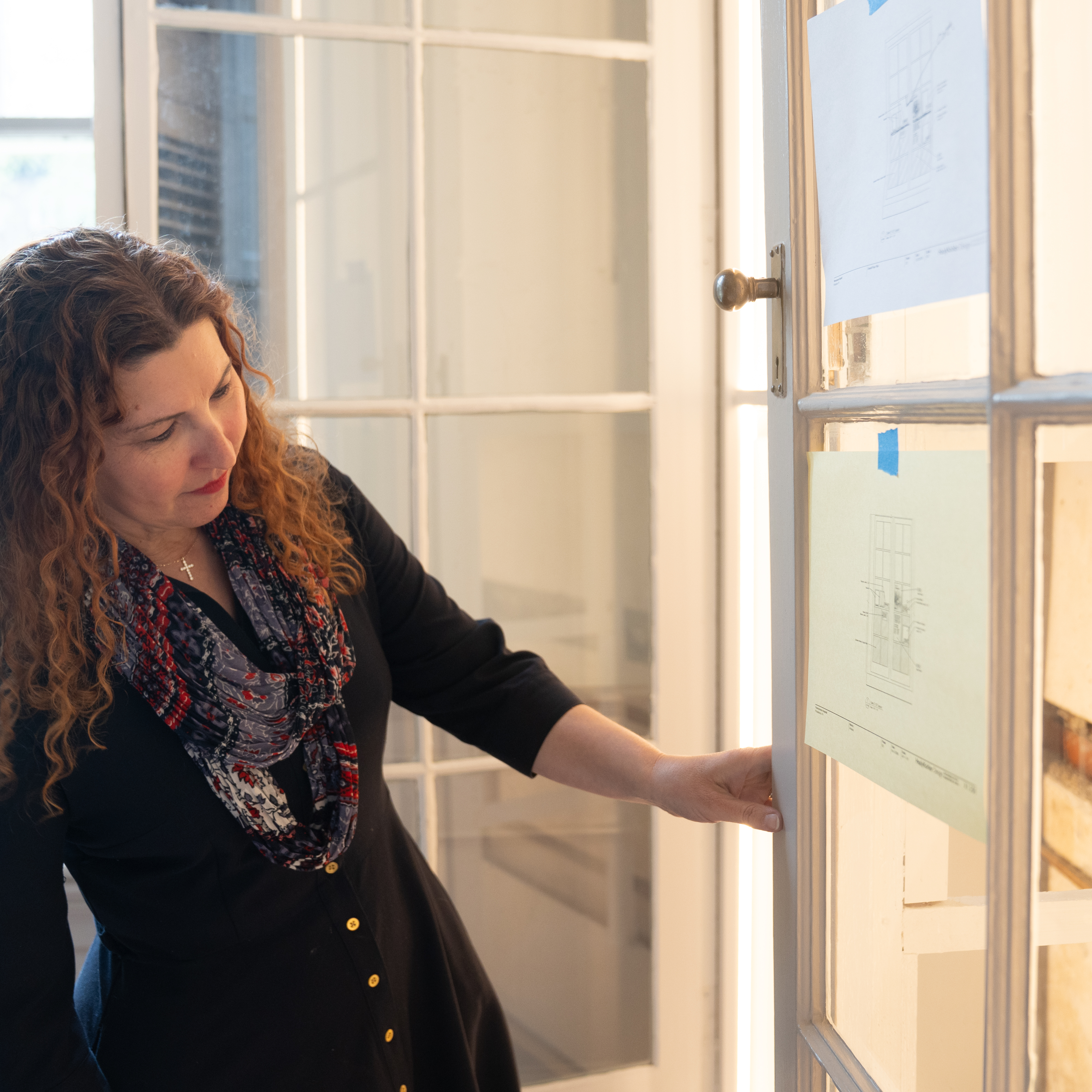 Stacey Peeples pointing to museum plans, with the original PAH wall exposed in background