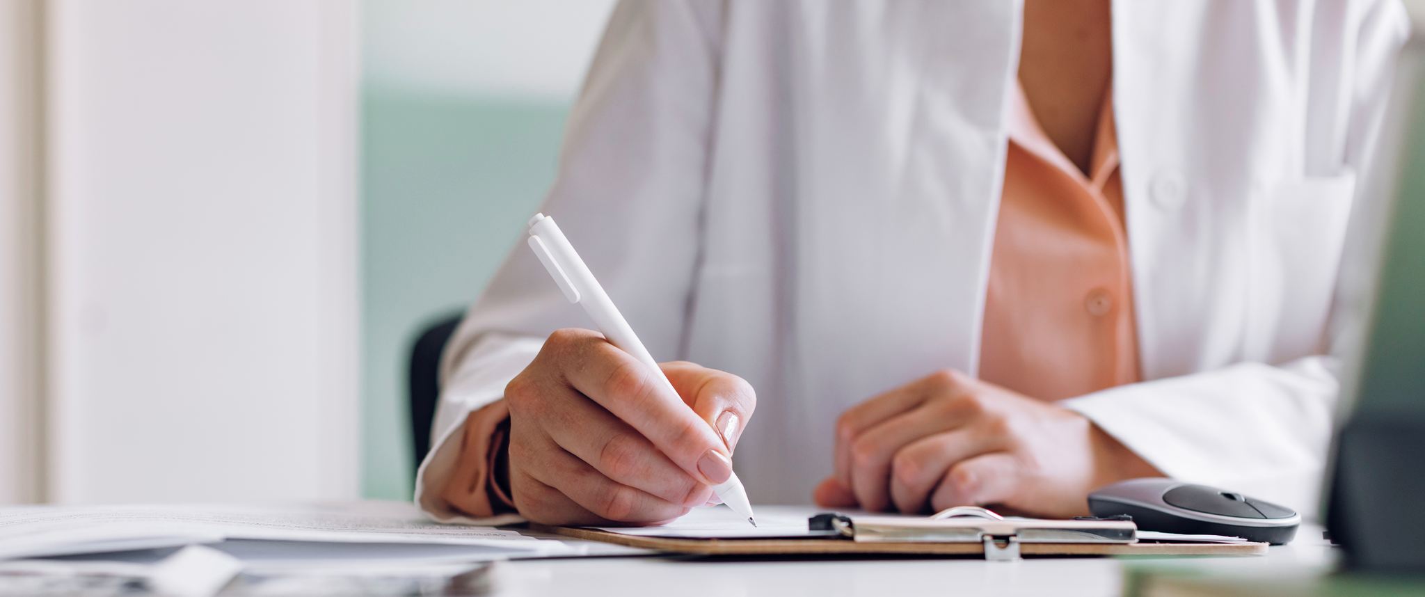 A physician writing on a clipboard
