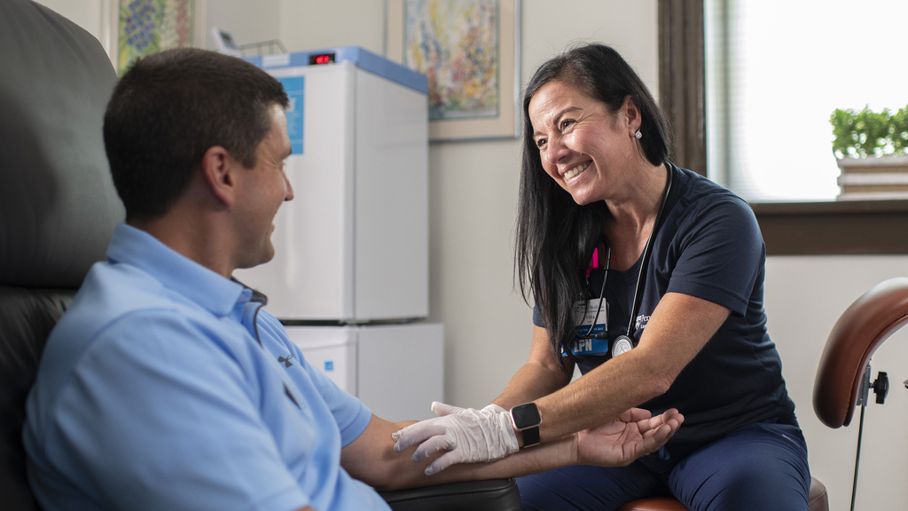 Vita Mazzola smiles interacting with a patient in an exam room
