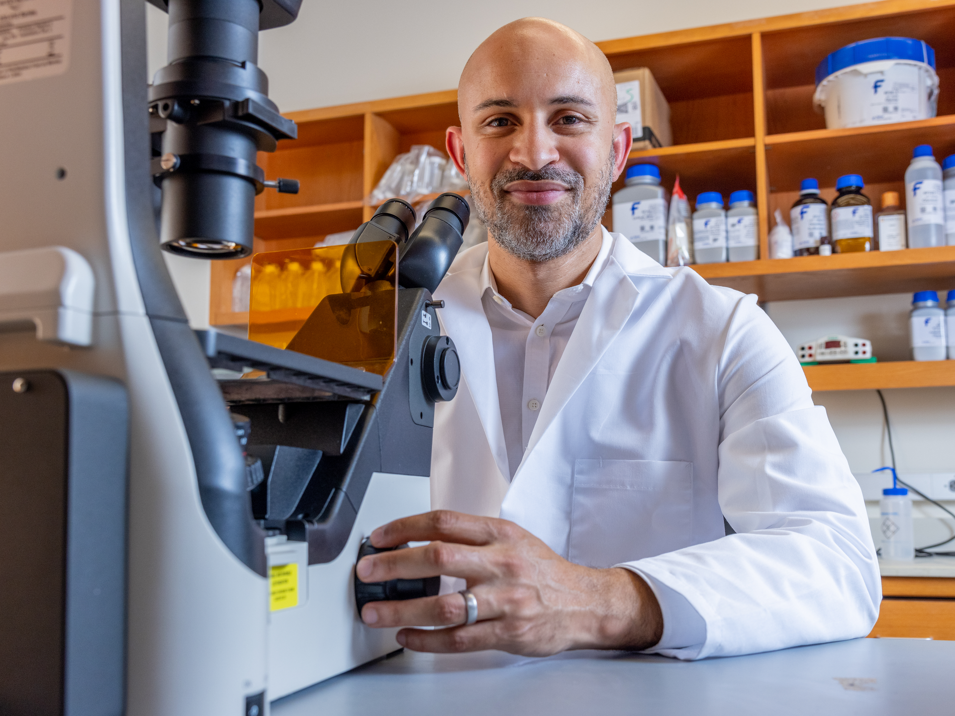Richard Edmund Phillips, MD, PhD, at microcope in brain cancer research lab