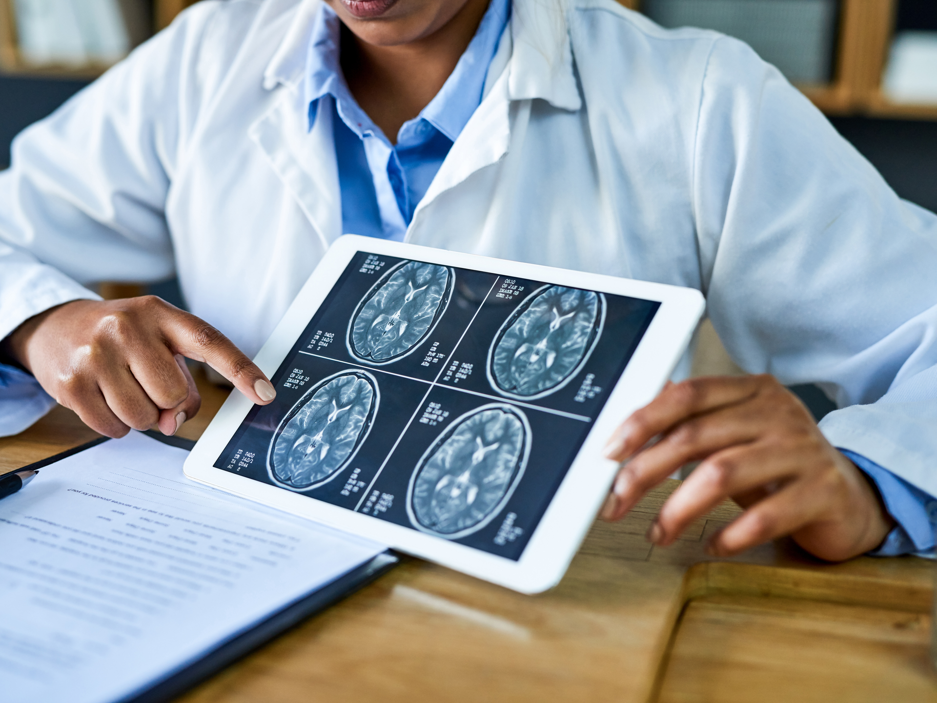 Doctor using a digital tablet to discuss a brain scan during a consultation in her office