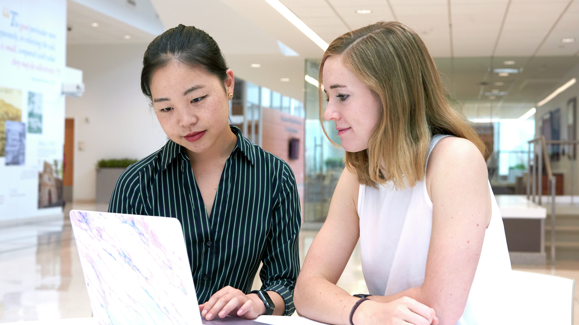 Emily Xu and Danielle Brown look at a laptop together