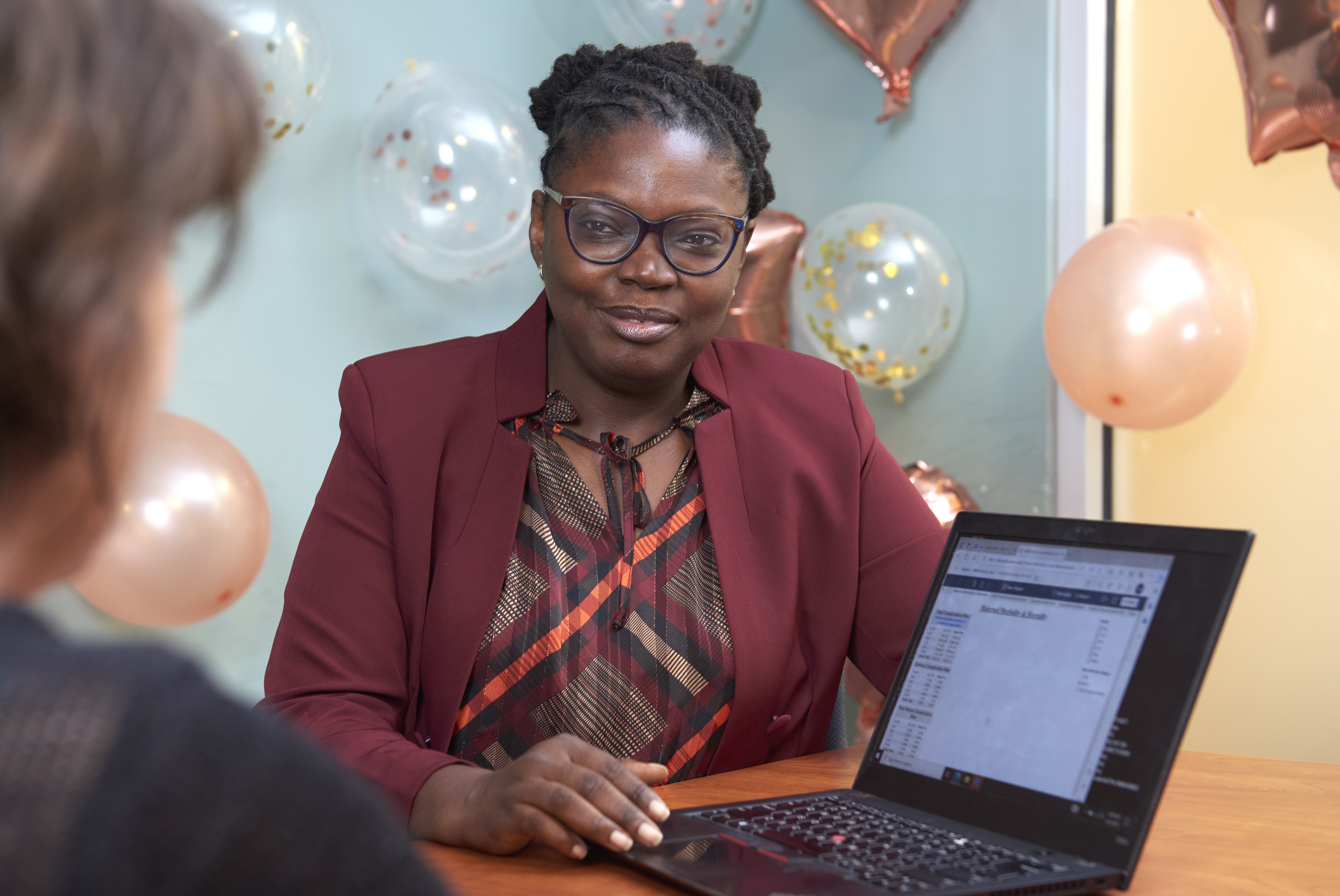 Abike James sits next to a laptop displaying data tables