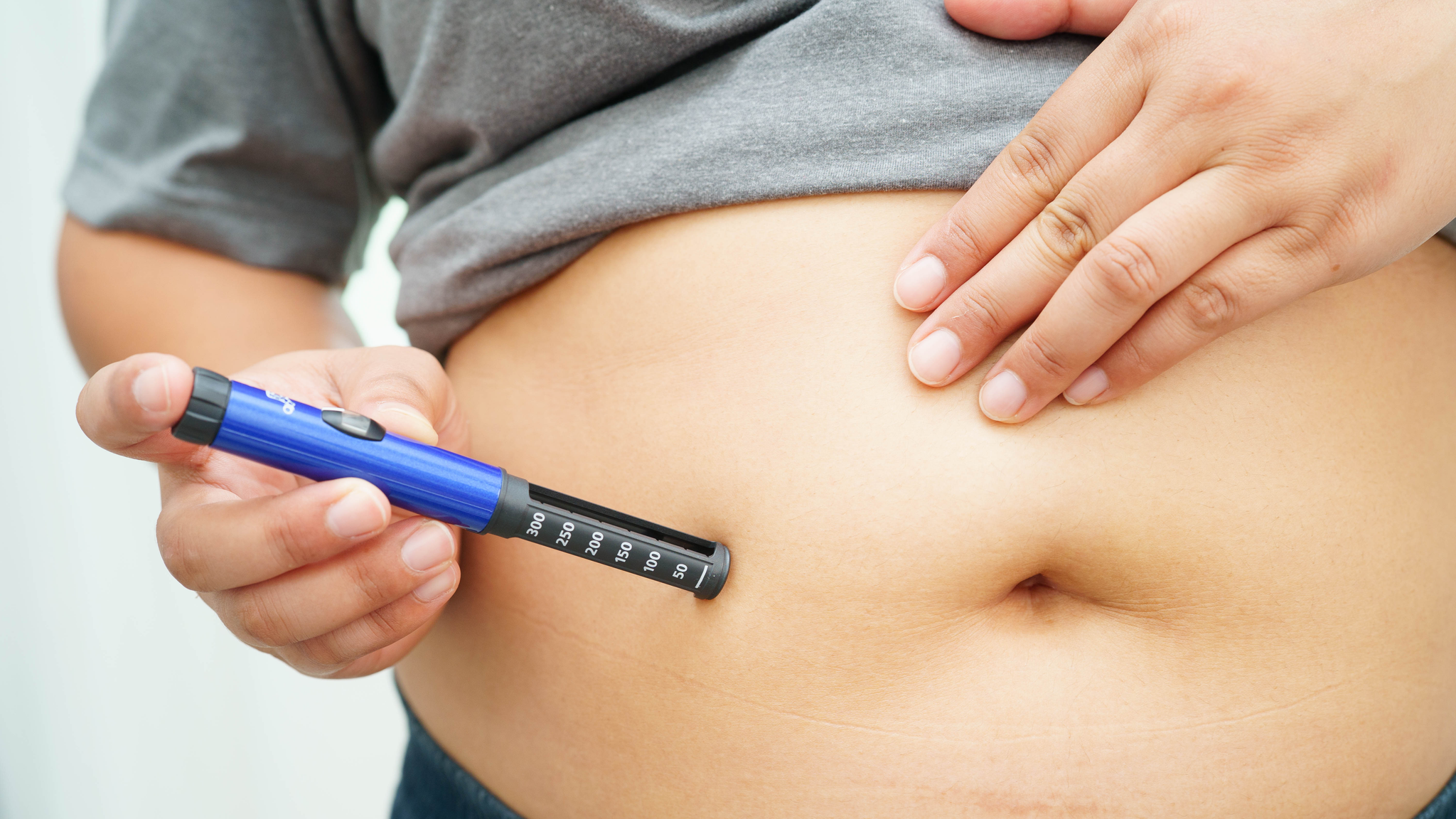 Woman applying obesity treatment on her belly.