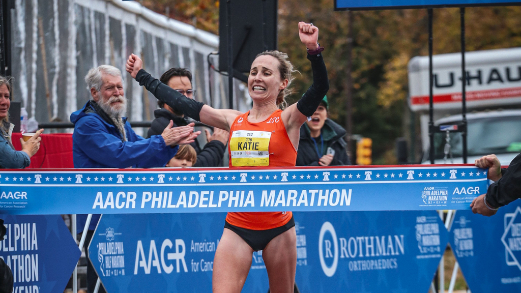 Katie Florio runs as the winner about to cross the finish line of the Philadelphia Marathon with her arms raised in victory