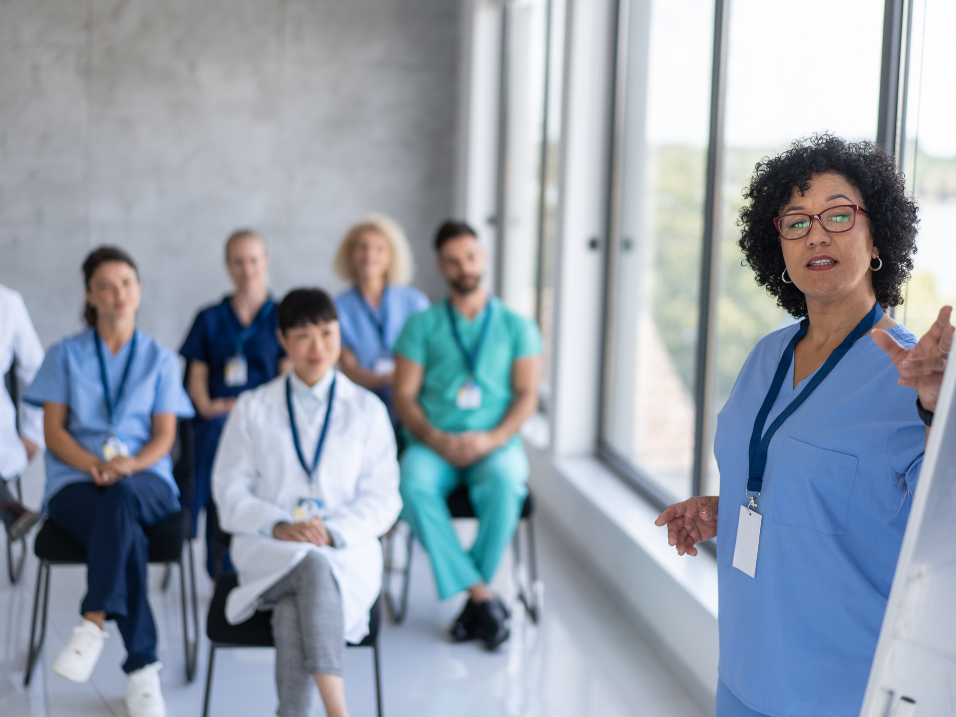 A healthcare professional leads a presentation, illustrating communication and teamwork during a training session.
