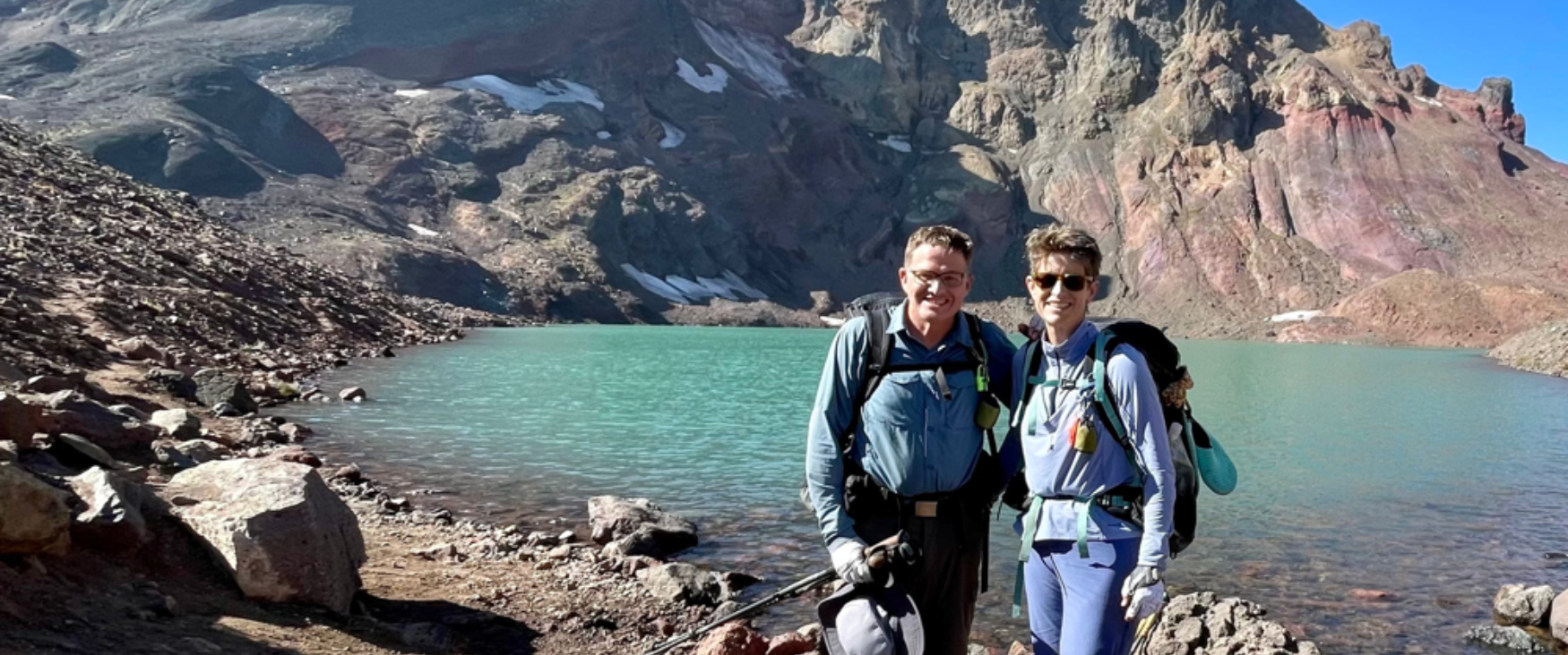 Kristen Hege with her husband in front of a mountaintop lake