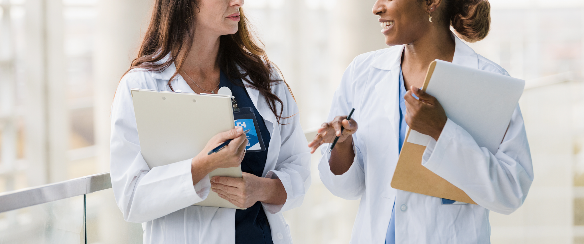 Two female doctors walk and talk together
