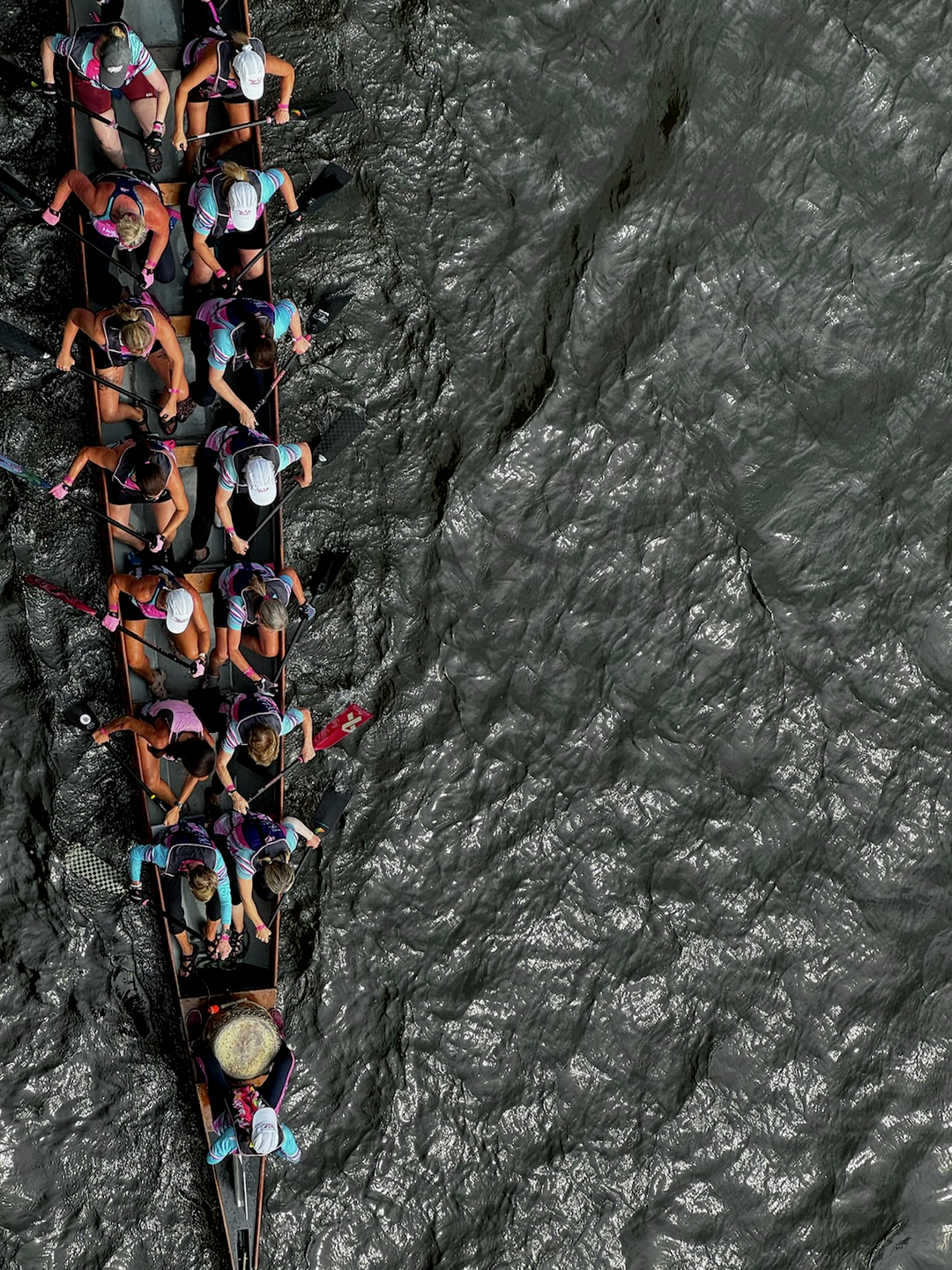 An aerial view of paddlers in a dragon boat in the water.