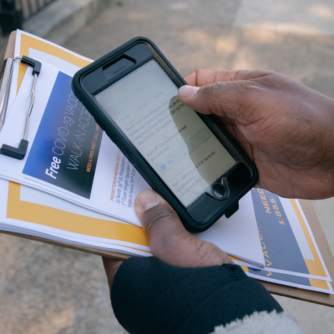 Close-up of a smartphone in the hands of Yuhnis Sydnor showing a script for discussing the COVID-19 vaccine