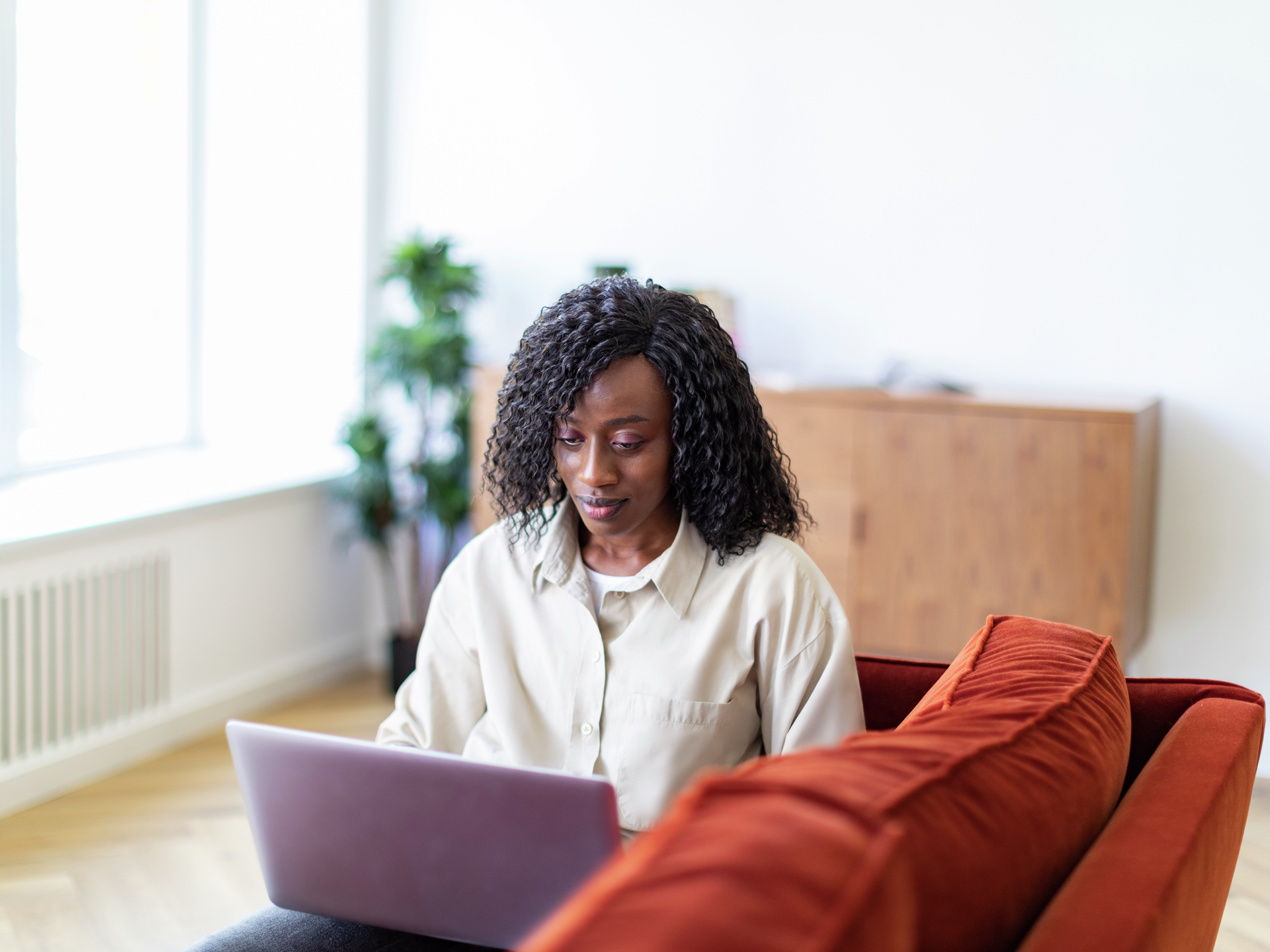 Young Black woman working with laptop from home