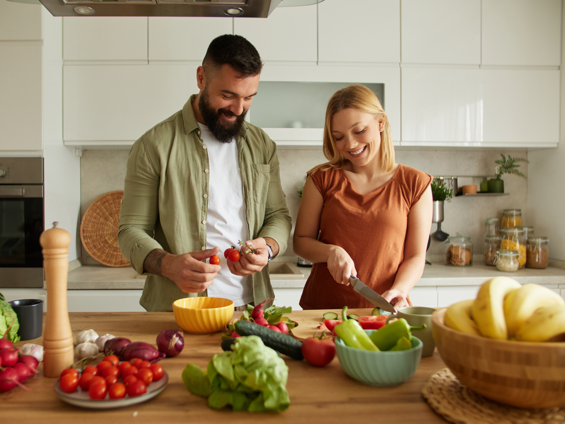 Affectionate couple cutting vegetable in the kitchen