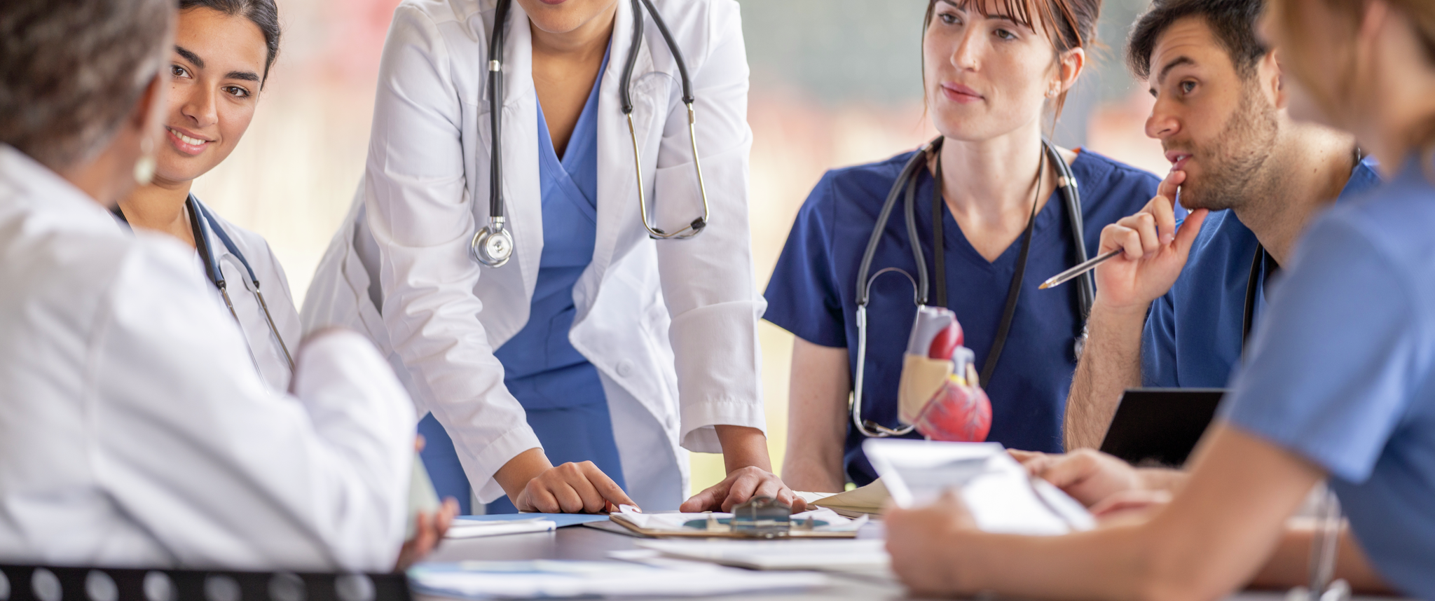 Medical professionals discussing idea around table in meeting room