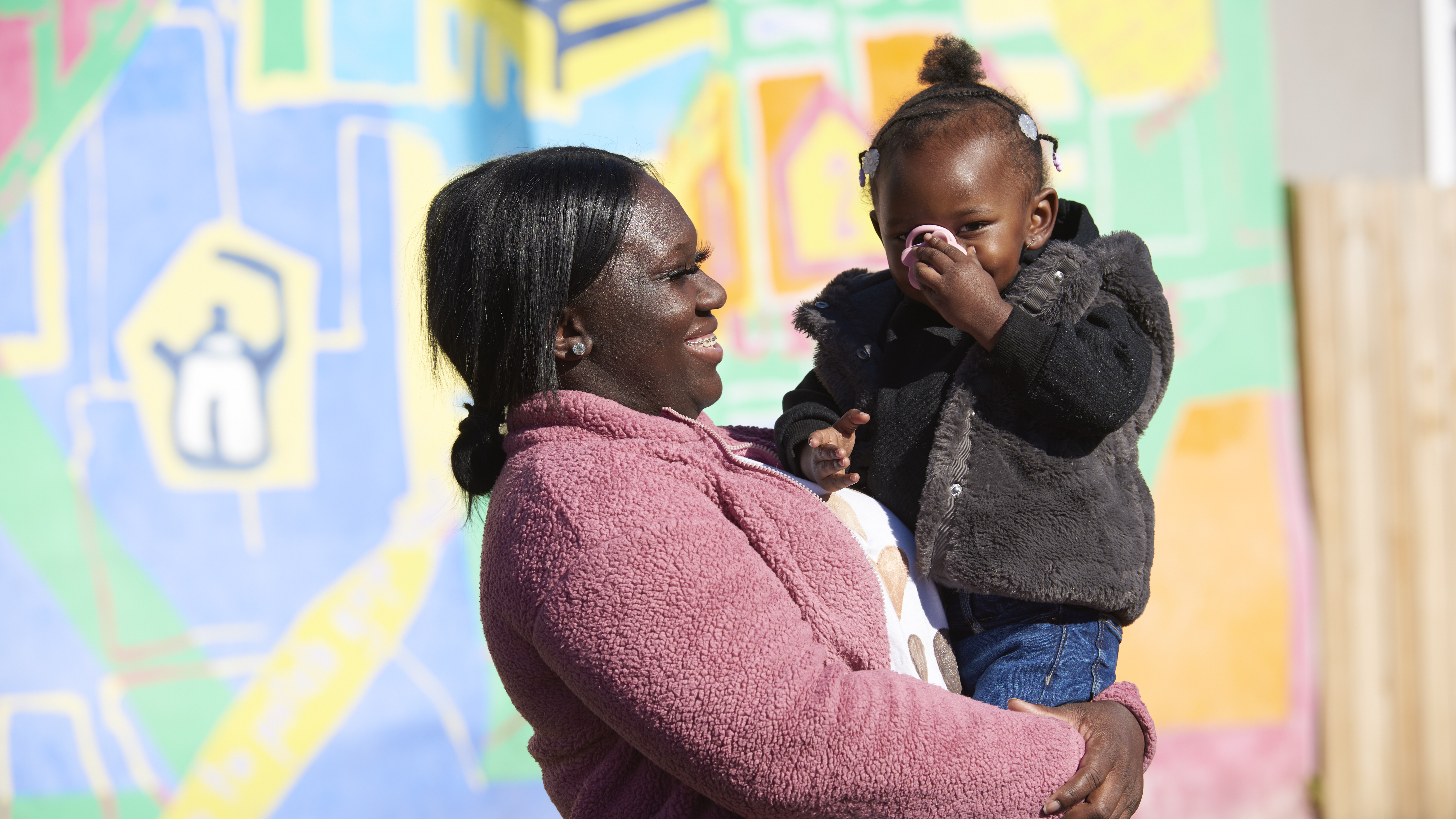 Black mother looks lovingly at her toddler daughter