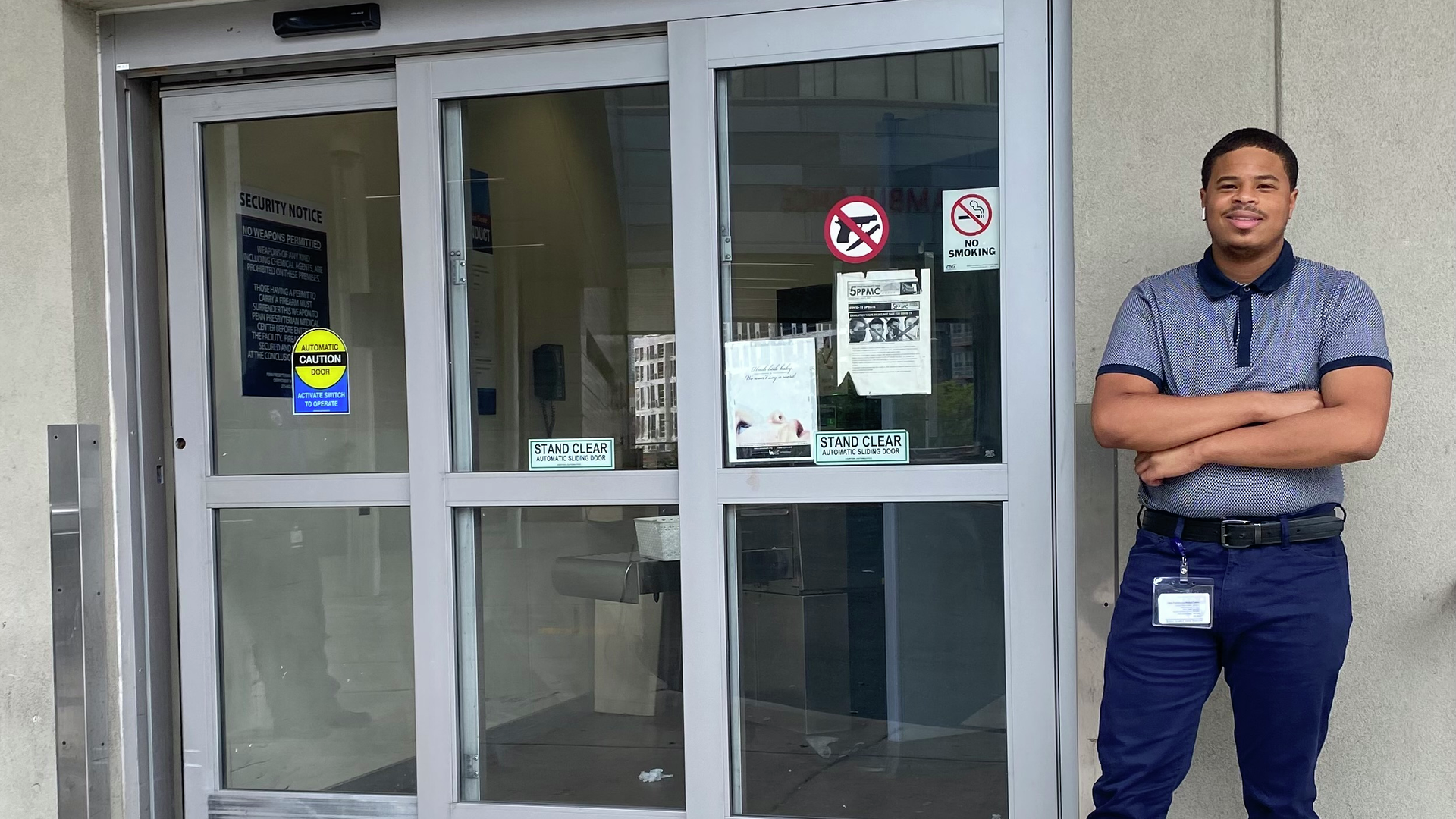 Rodney Babb, a young Black man, stands outside the emergency entrance at Penn Presbyterian Medical Center