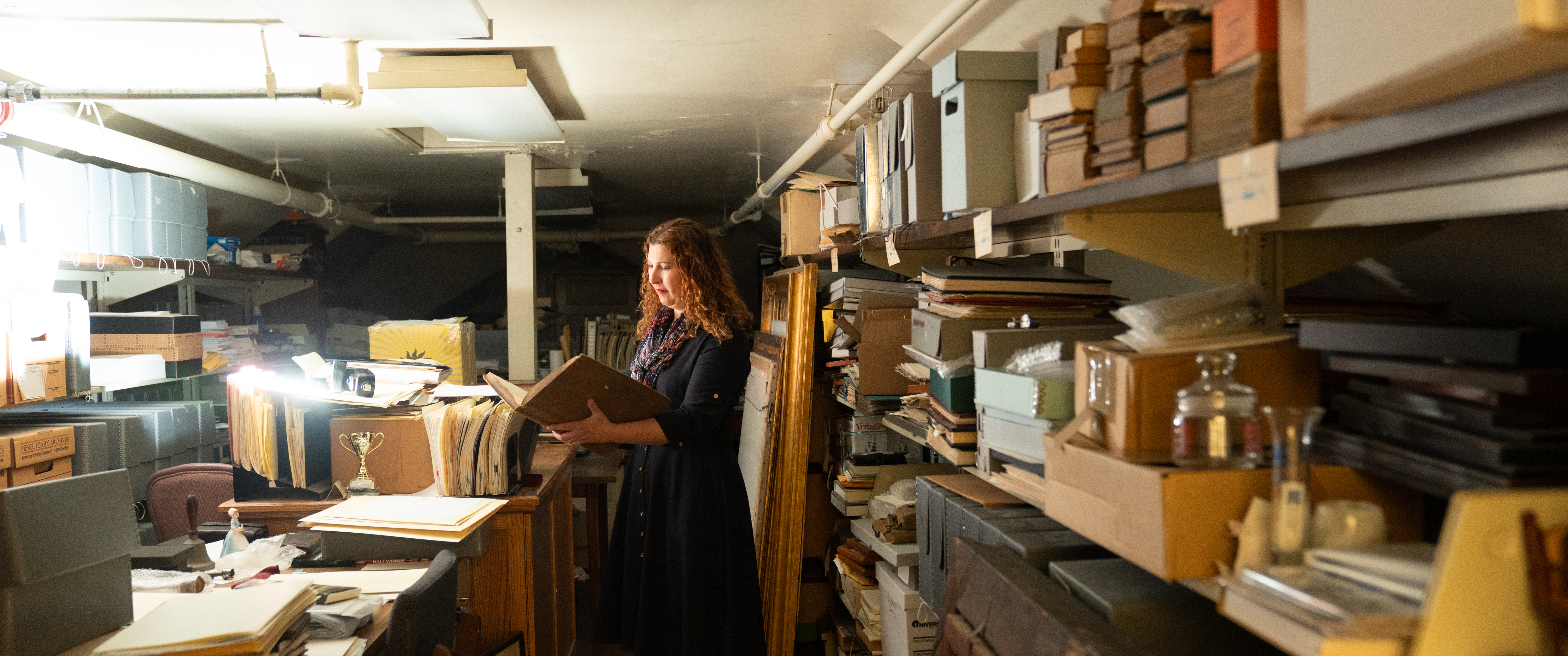 Stacey Peeples holding an old book in the Pennsylvania Hospital archives