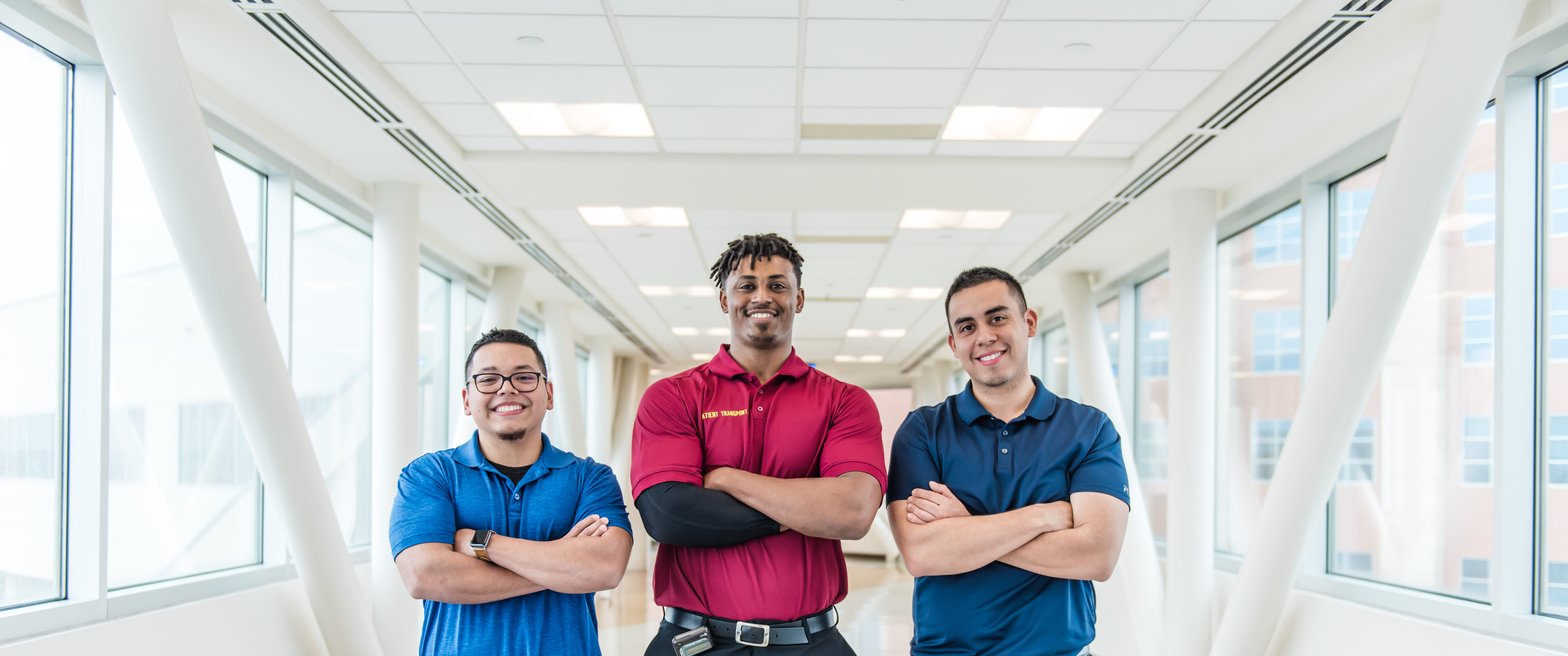 Three healthcare professionals standing in front of a stretcher.