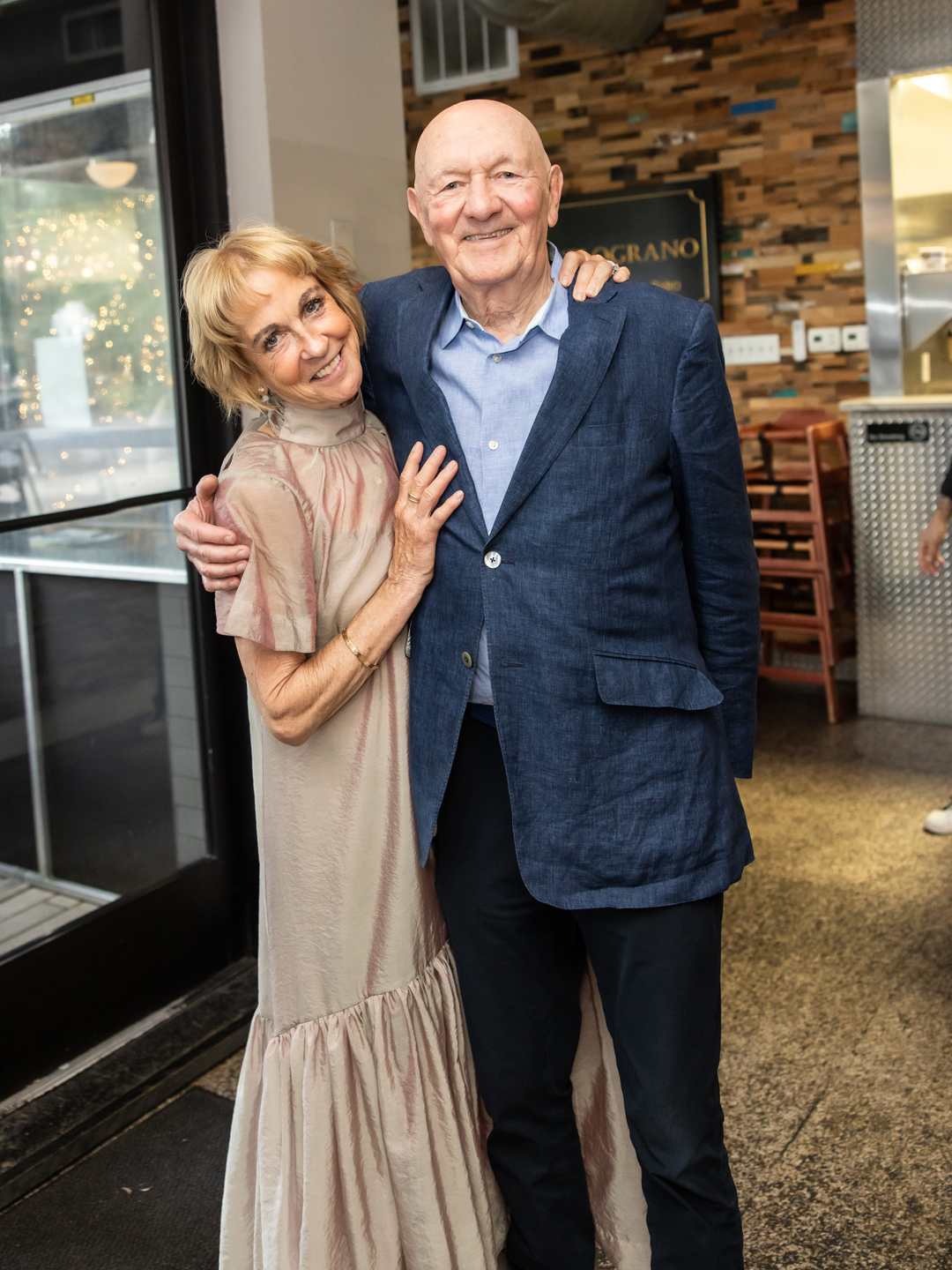 Beth Johnston and Ralph Muller embrace while standing and smiling