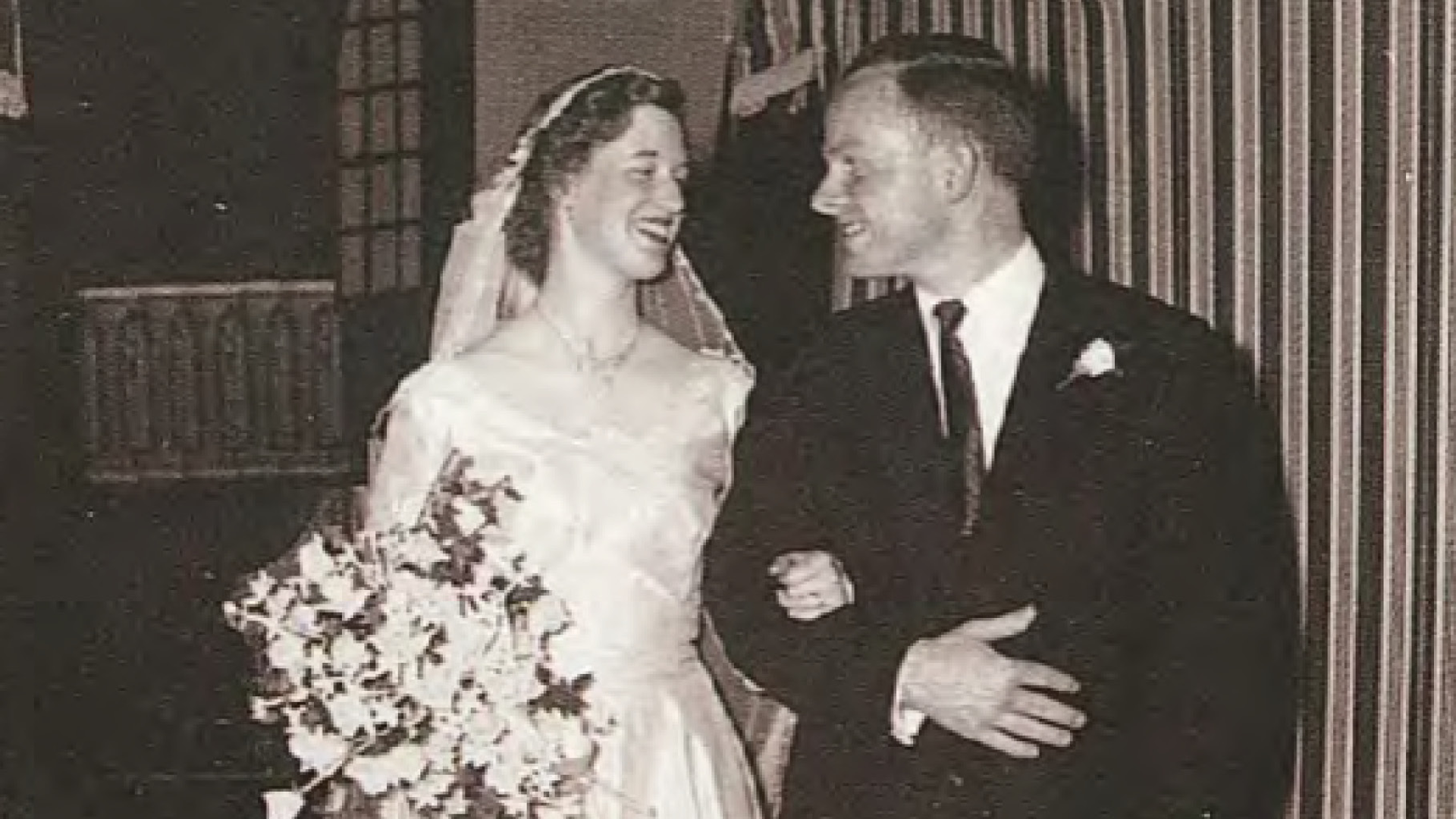 A black and white photo of a bride and groom smiling at each other
