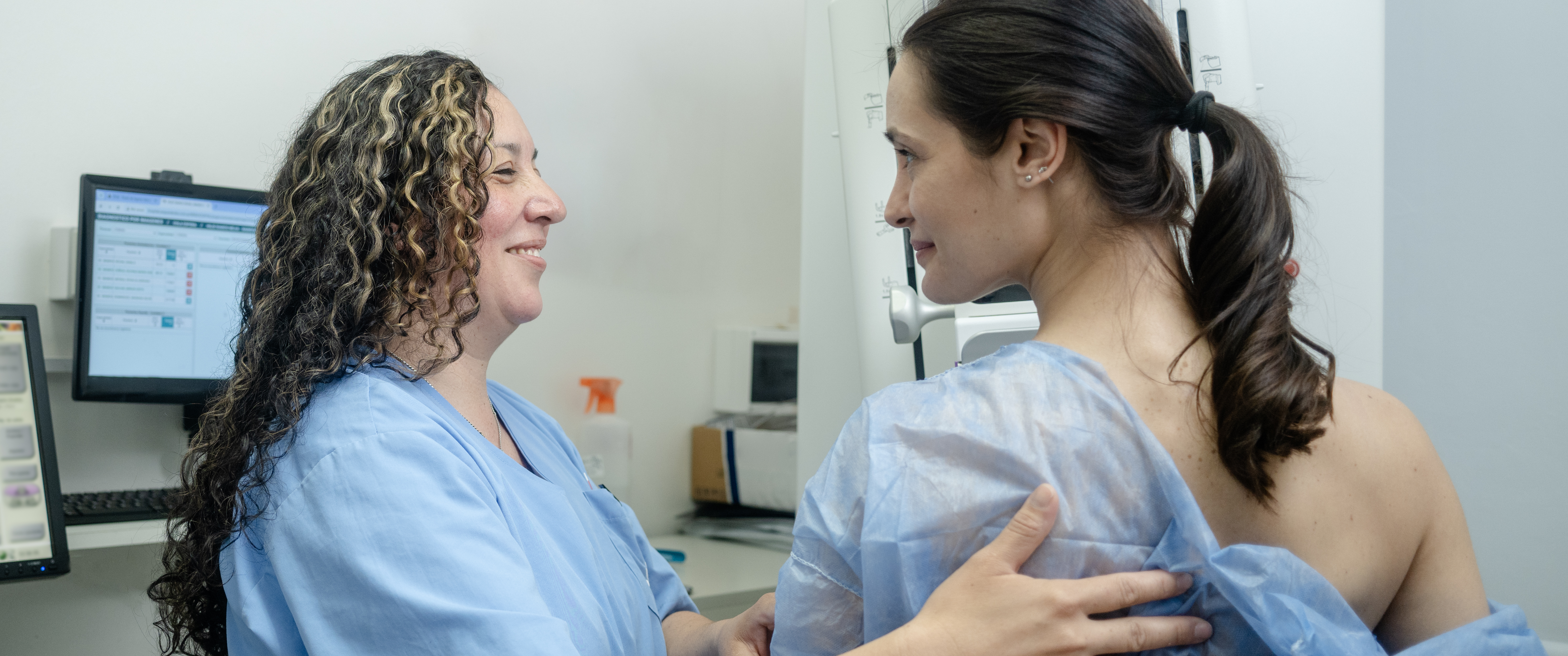 A technician helping a woman having a mammogram