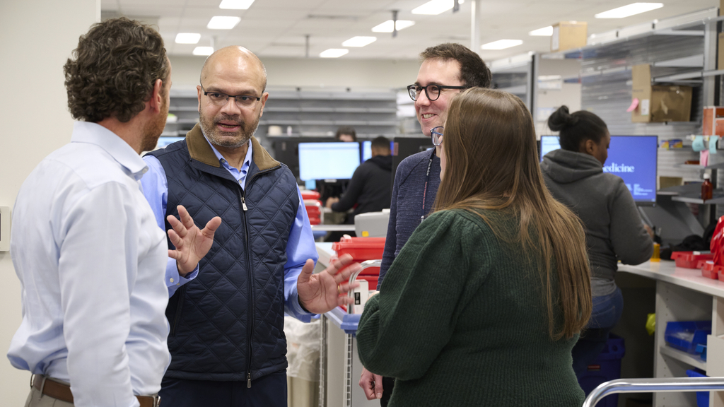 Mohan Balachandran talks with Way to Health and pharmacy staff in a pharmacy staff area 