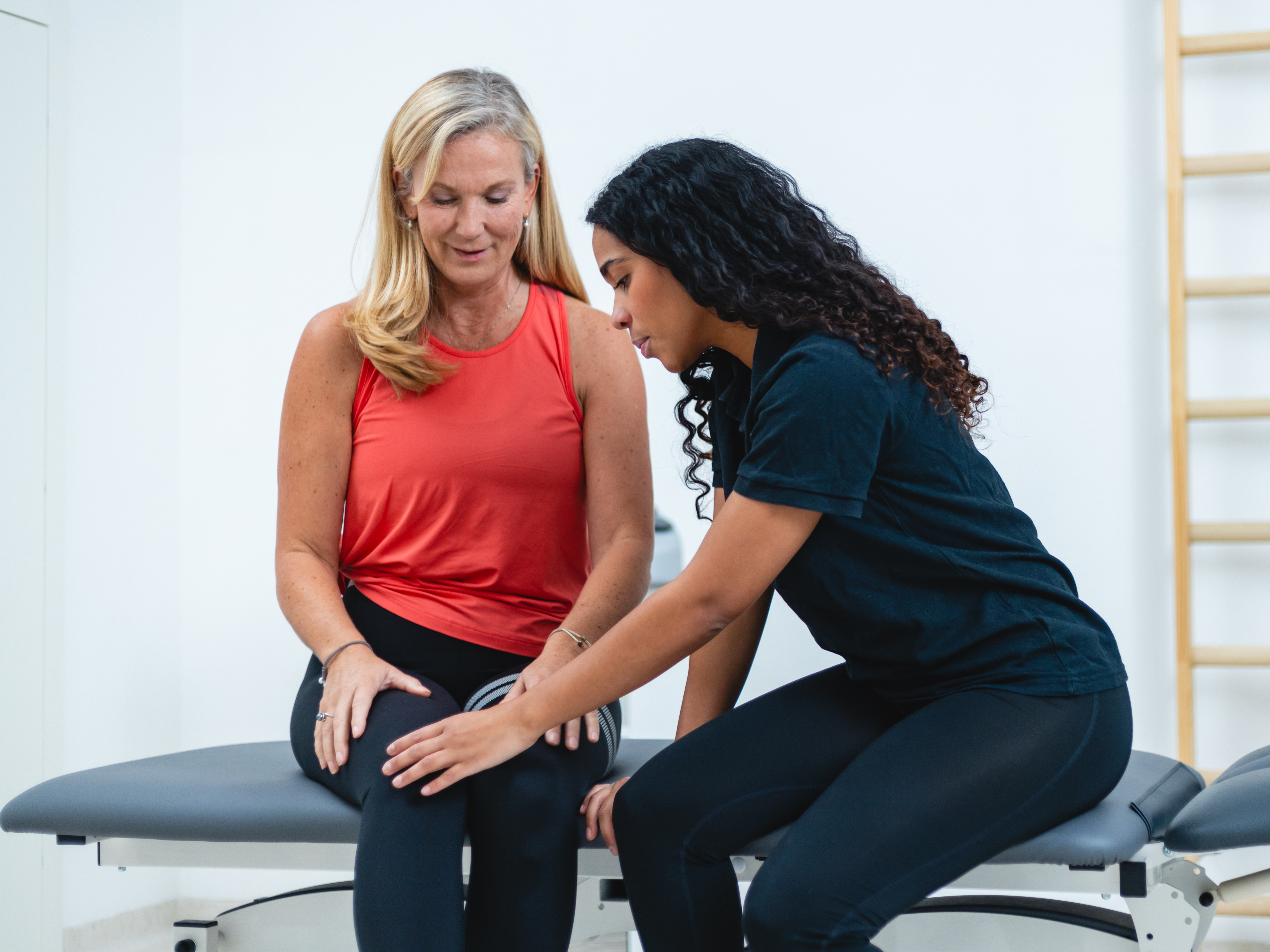 Physiotherapist helps a female patient with her knee in rehabilitation clinic