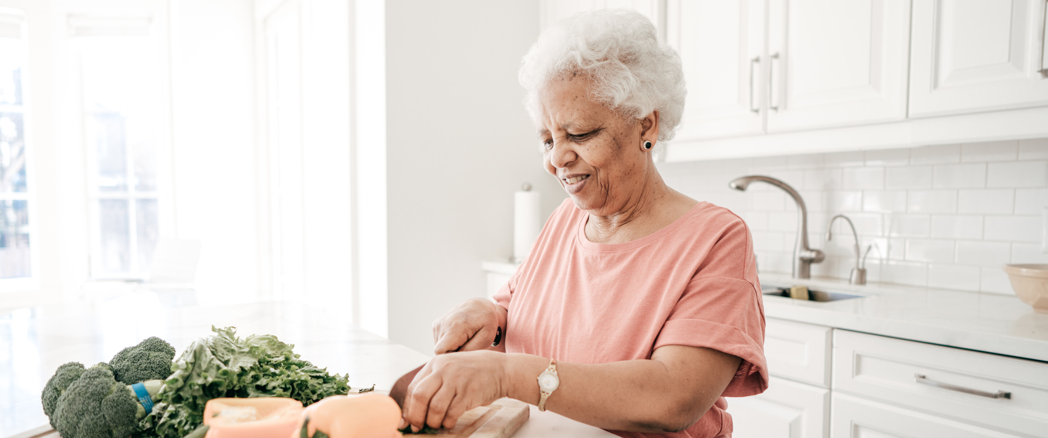 Senior woman cutting vegetables in the kitchen