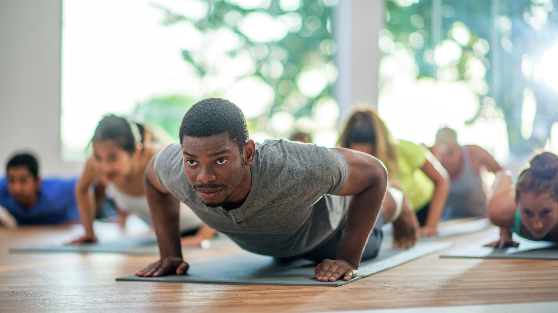 Group of adults holding plank position in yoga class
