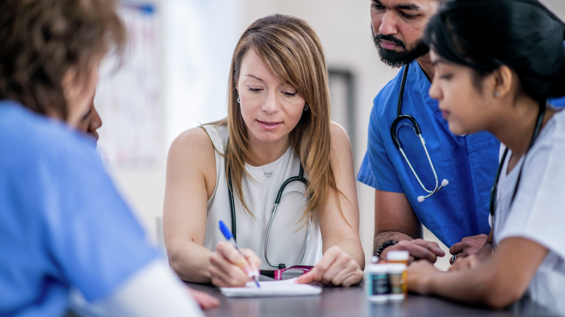 Diverse group of doctors meeting, taking notes