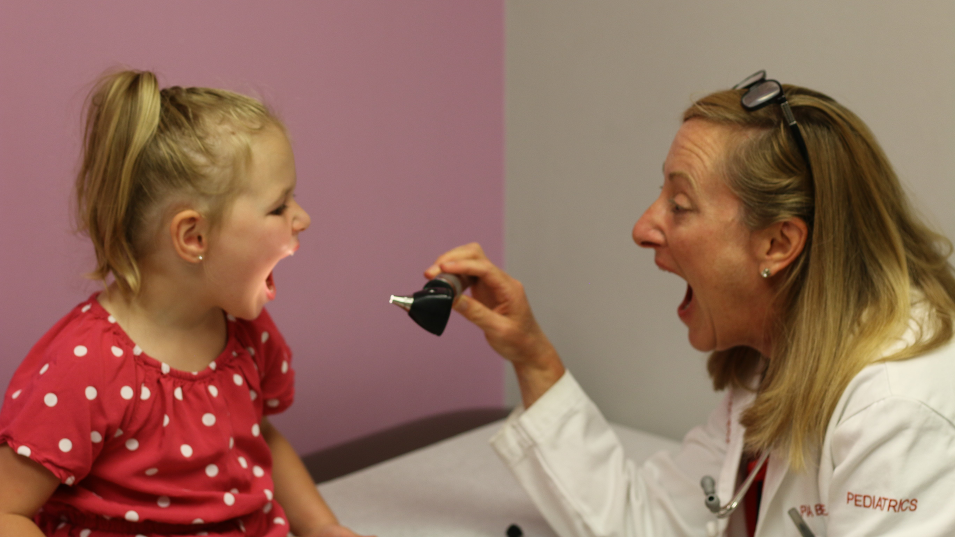 Pia Fenimore shining a light in the mouth of a pediatric patient at an appointment