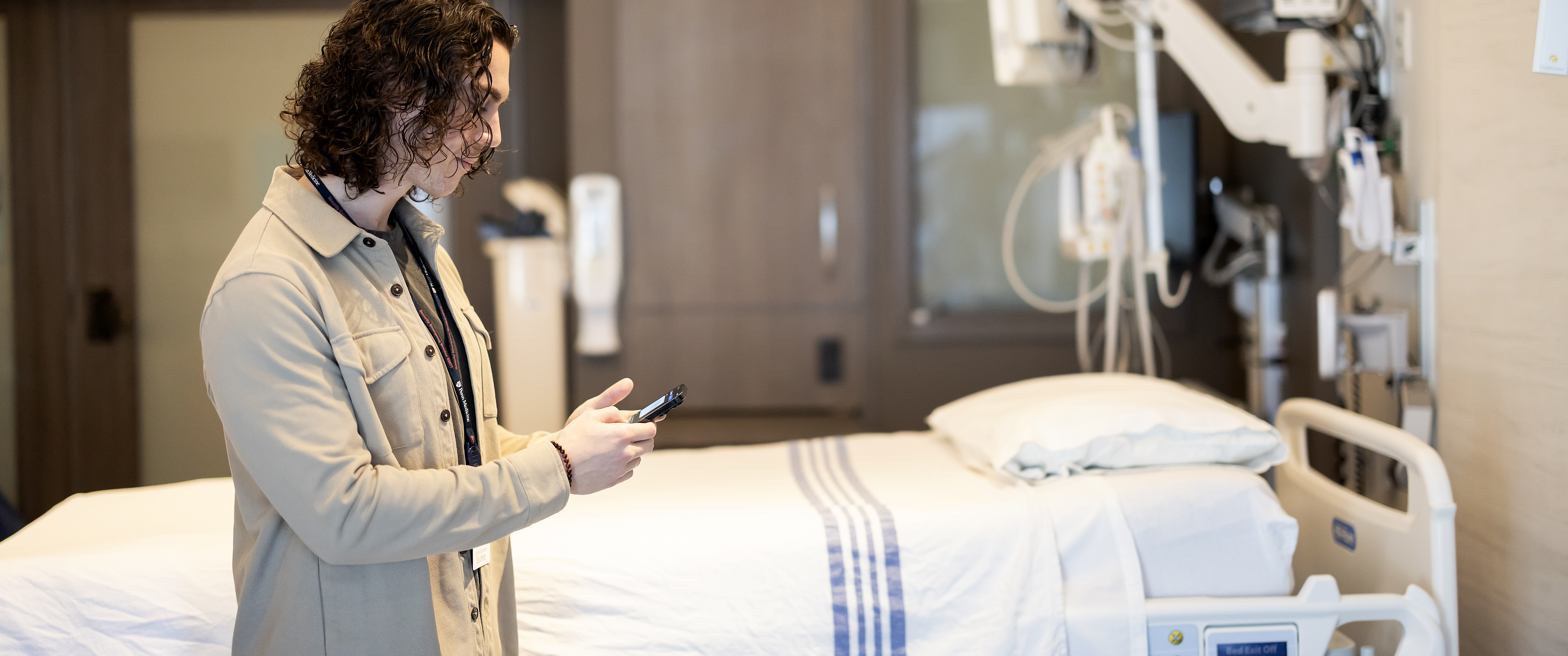 A person texting on their phone in a hospital room