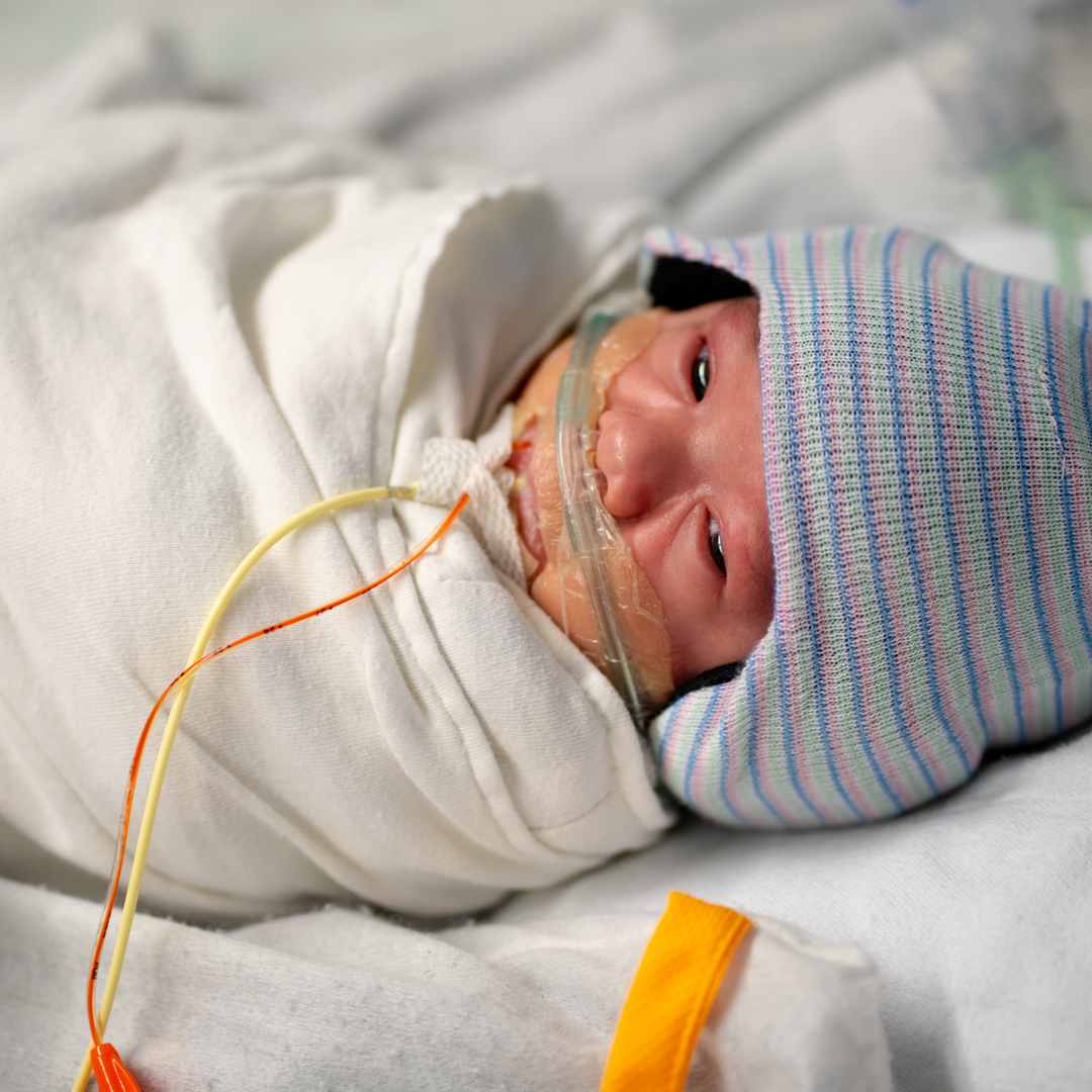 Baby John Collins lays comfortably listening to his mother’s voice played through the Sonura Beanie