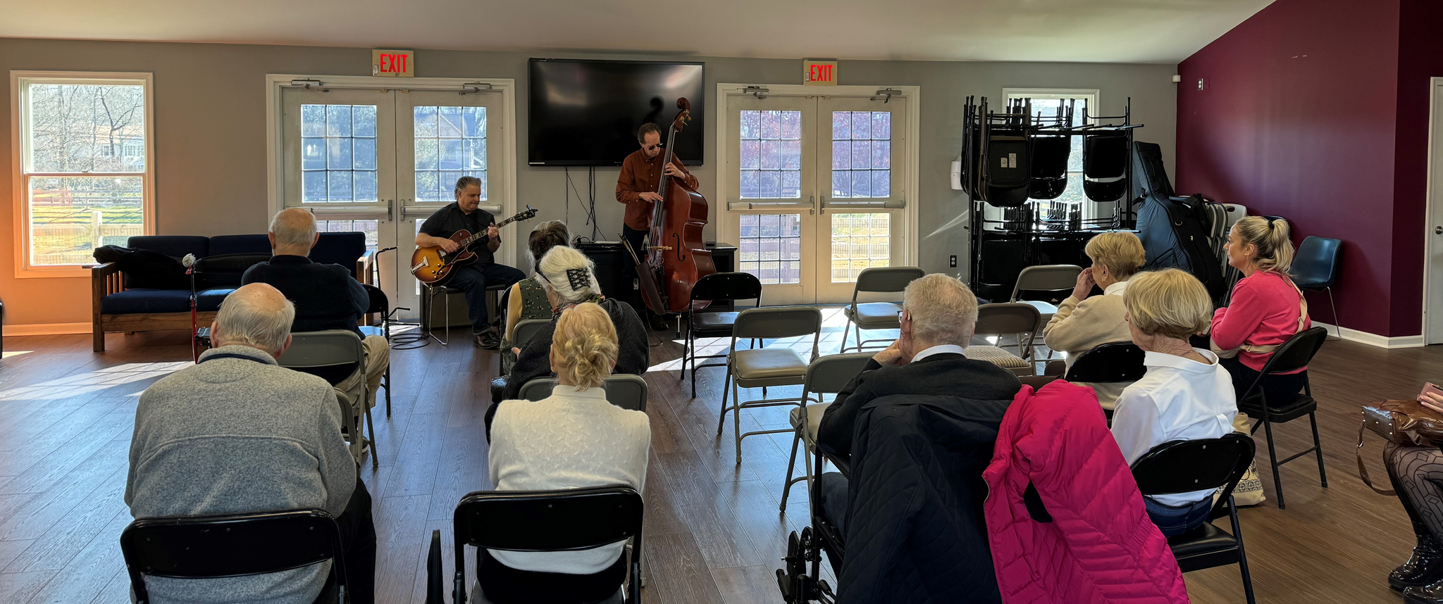people sitting in chairs listening to live music