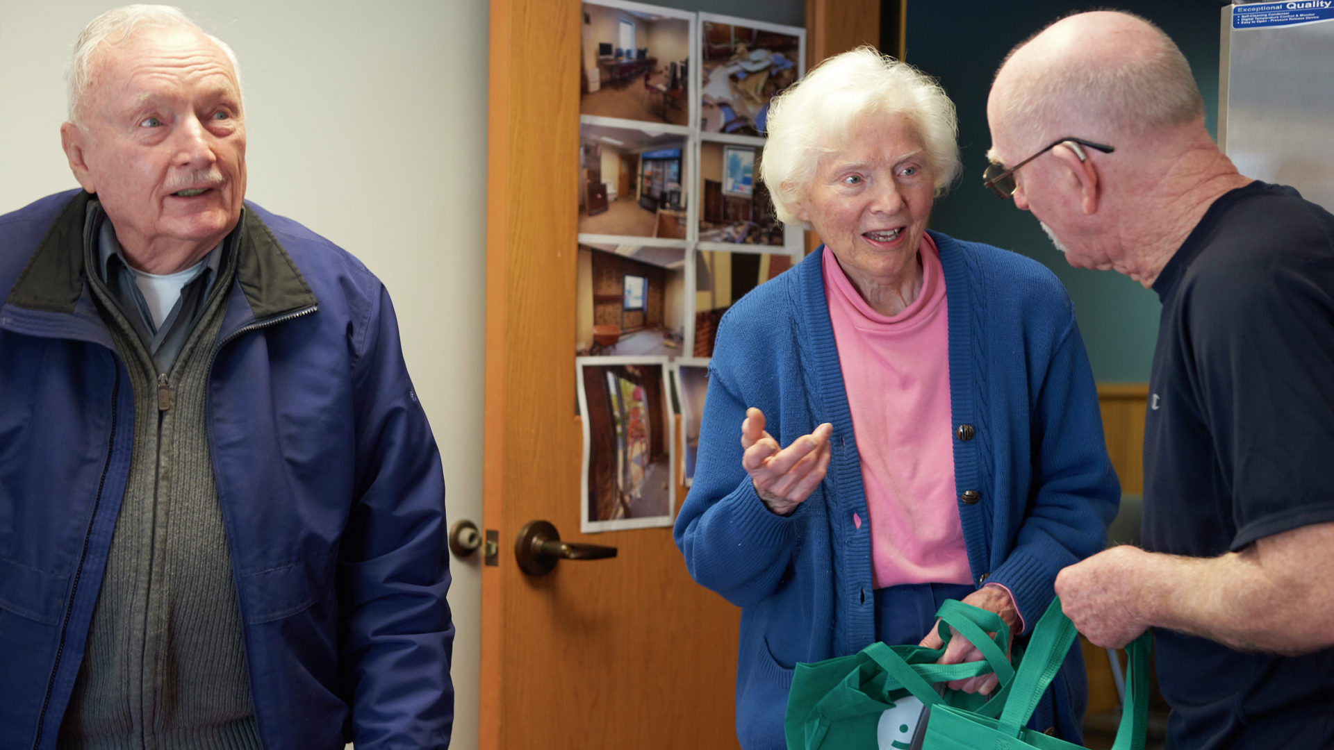 Three seniors talk with one another