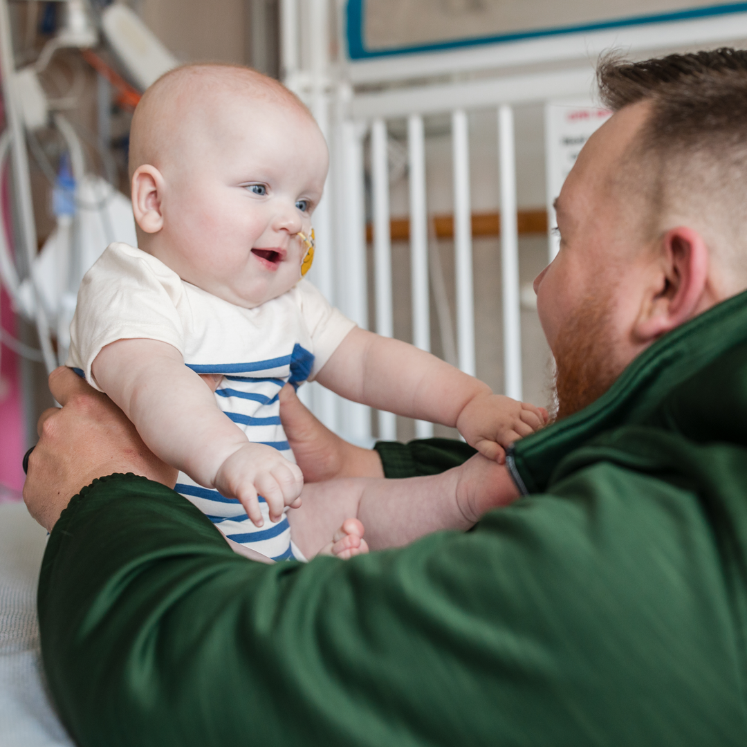 Dad Kyle plays with a chubby-cheeked 9-month-old baby KJ