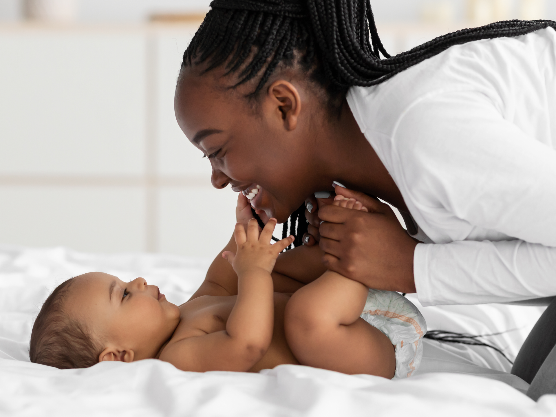 Closeup profile of black mother playing with infant
