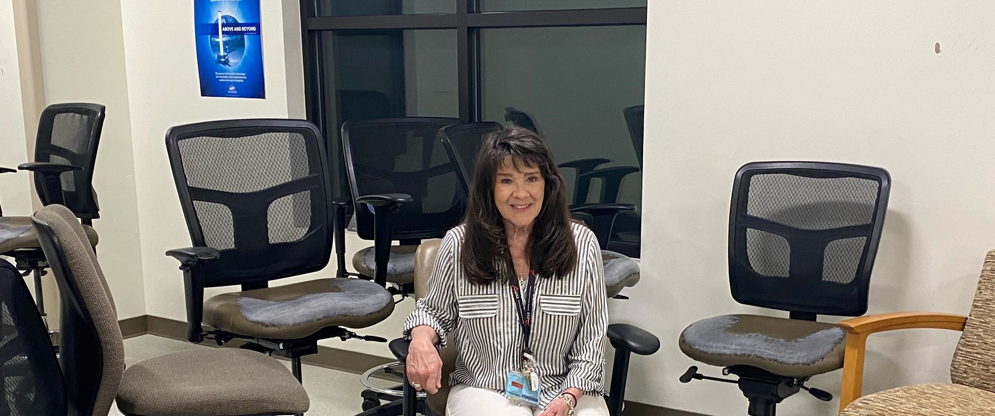 Mim Lambros, an equipment planning specialist at Lancaster General Health, sits among a collection of gently used office chairs