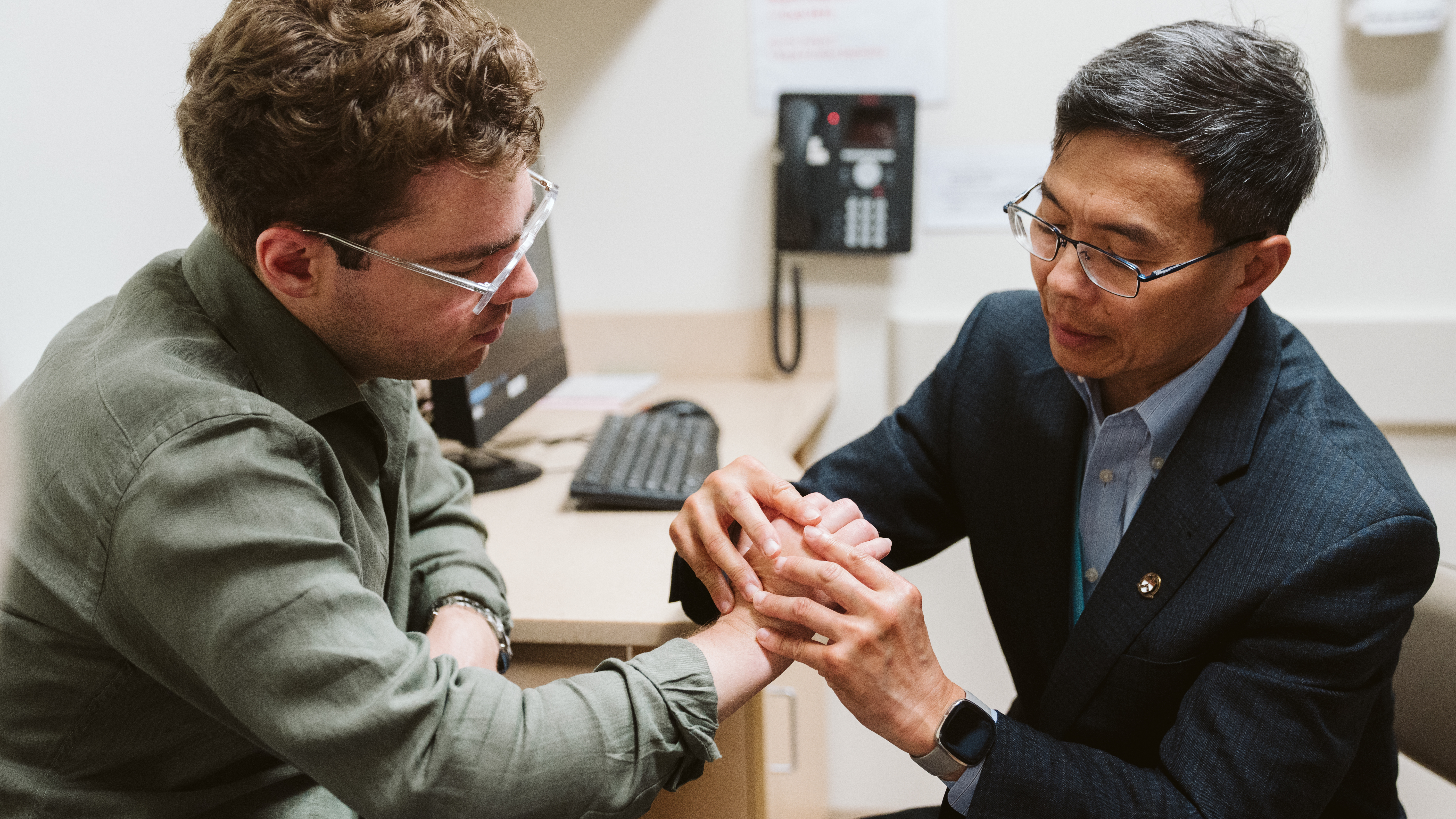 Plastic surgeon Benjamin Chang examining Luka’s hand during a follow-up visit