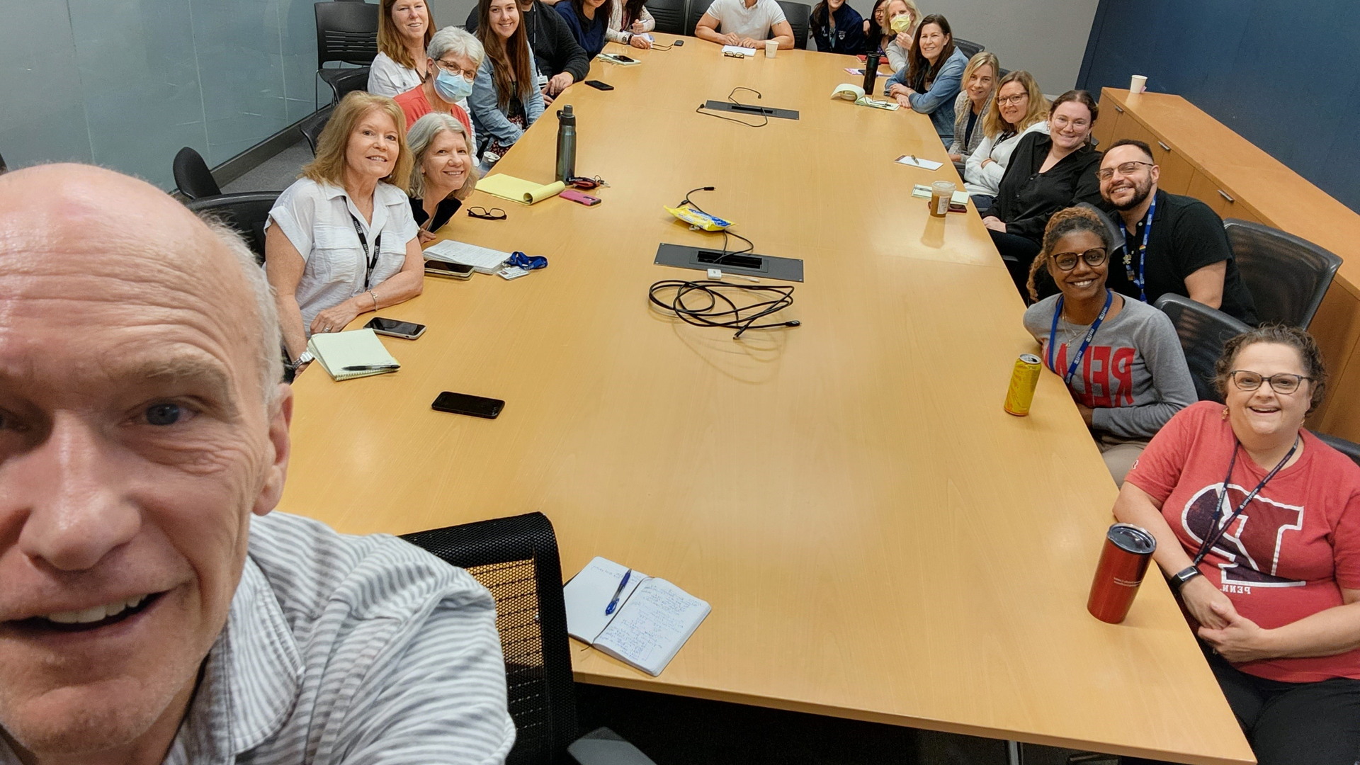 Carl June taking selfie in front of Clinical Trial Unit members at a conference table