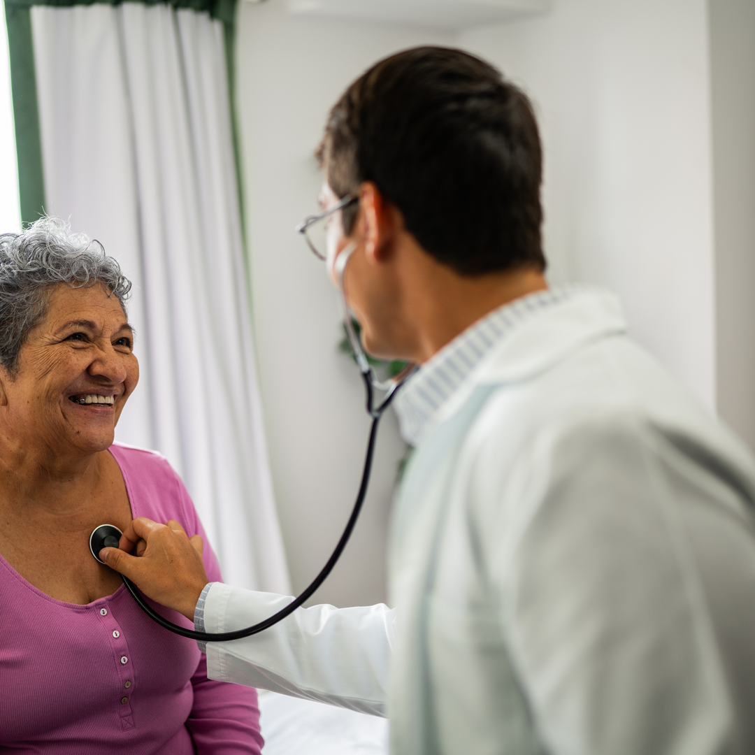 Doctor listening senior patient woman's heartbeat during consultation at hospital