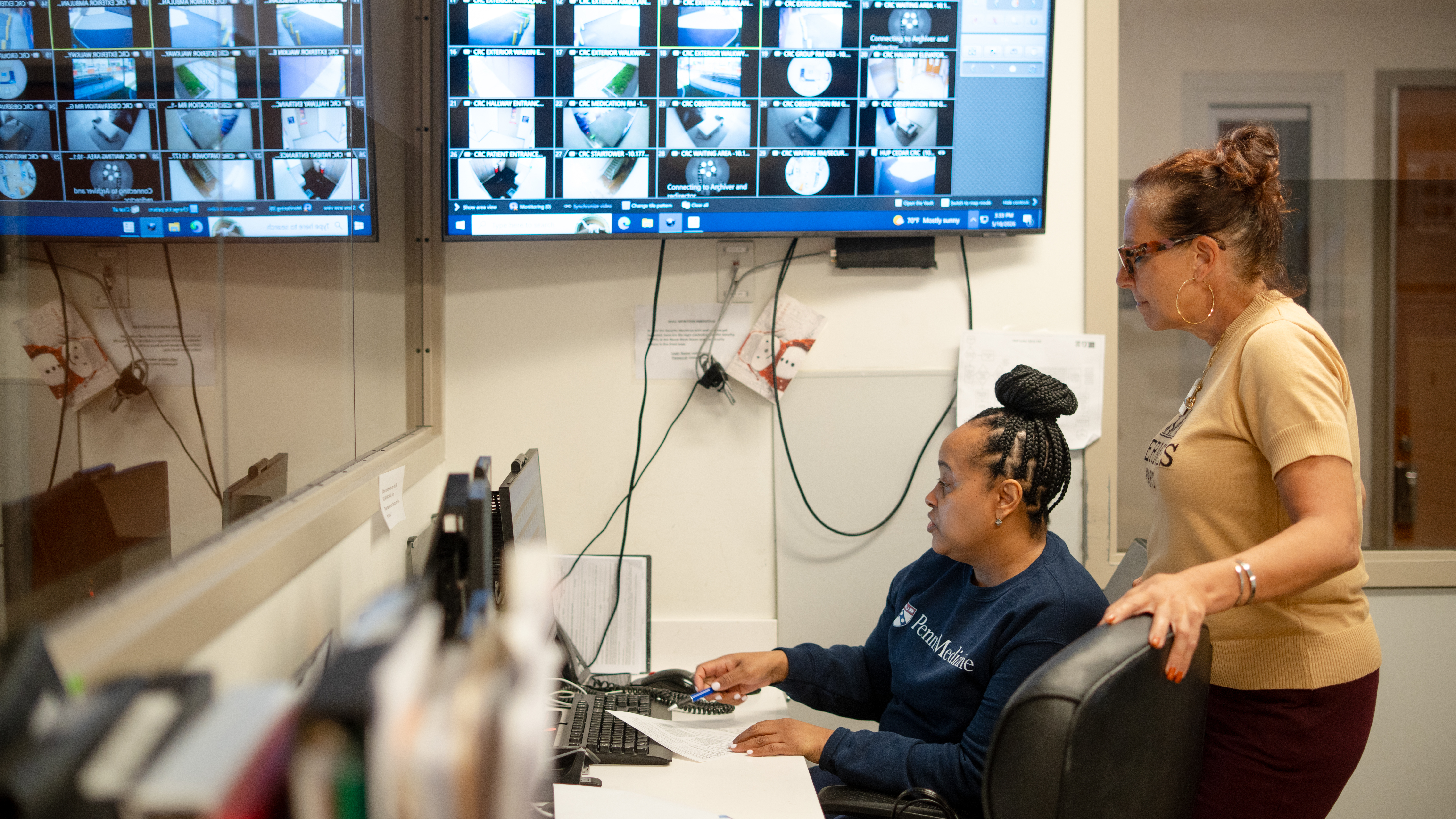 Two female staff members reviewing information at a nurses station