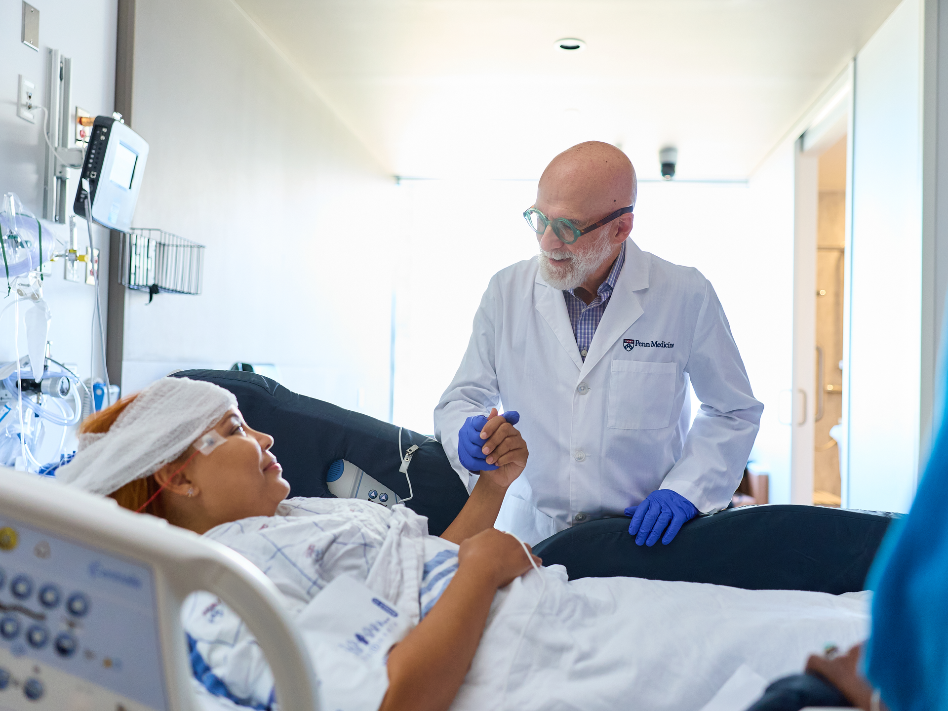 A neurologist meets a patient in her hospital room