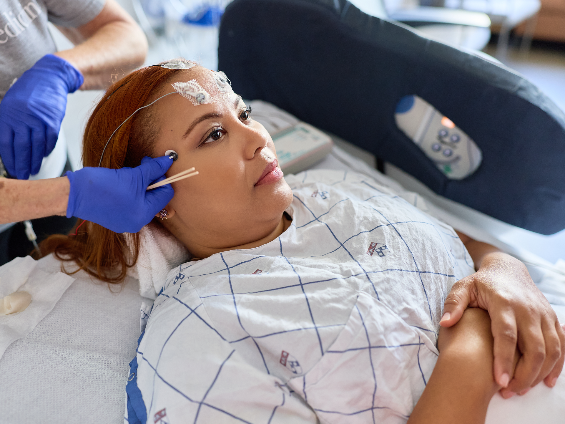 Nurse applying nodes on a patient forehead in an hospital  room